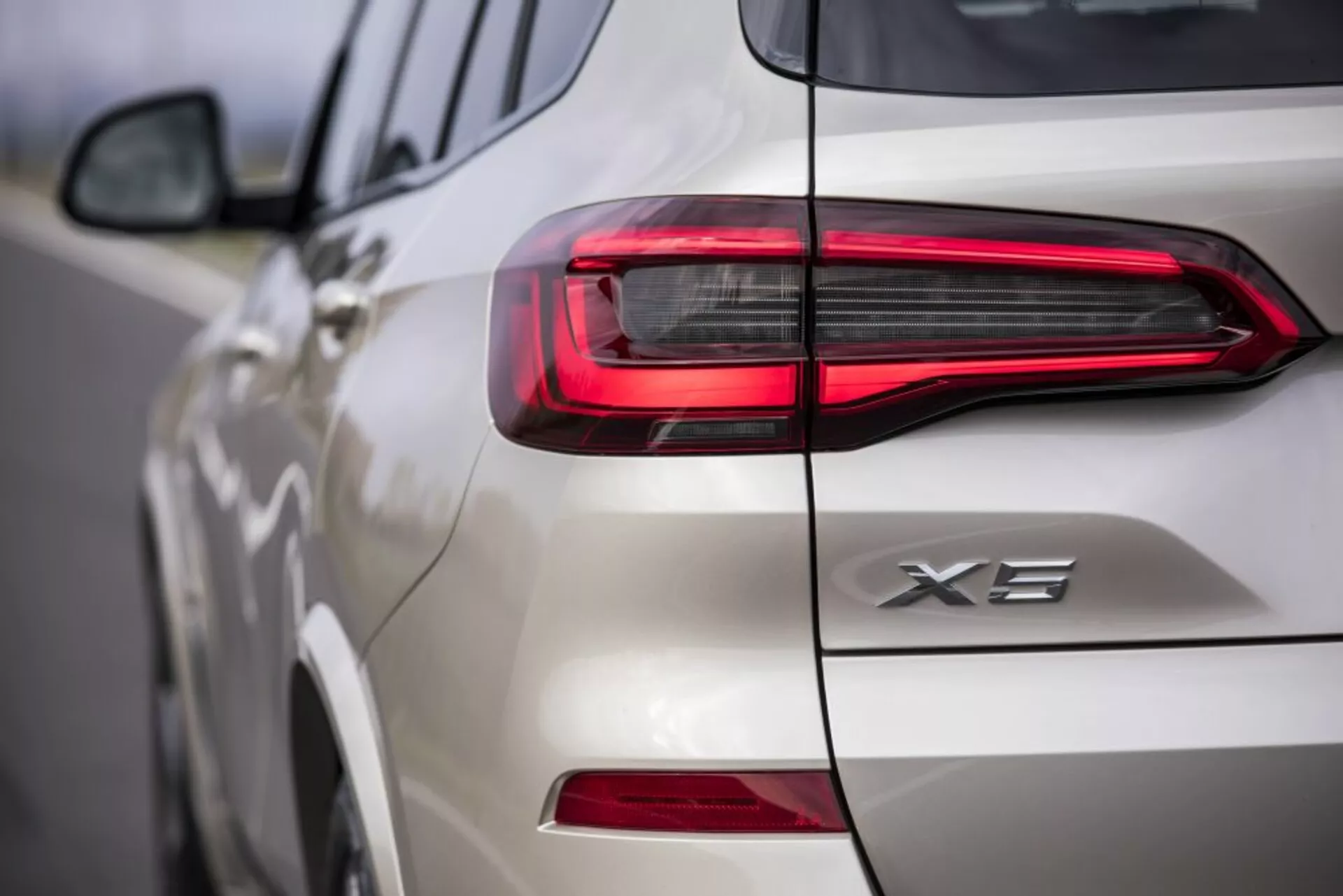 Közelkép egy fehér 2018-as BMW X3 hátsó részéről, bemutatva a LED-es hátsó lámpa tervezését és az X3 jelzést, a jármű modern, vízszintes fényjegyére és a hátsó ajtó és oldal részleteire összpontosítva.