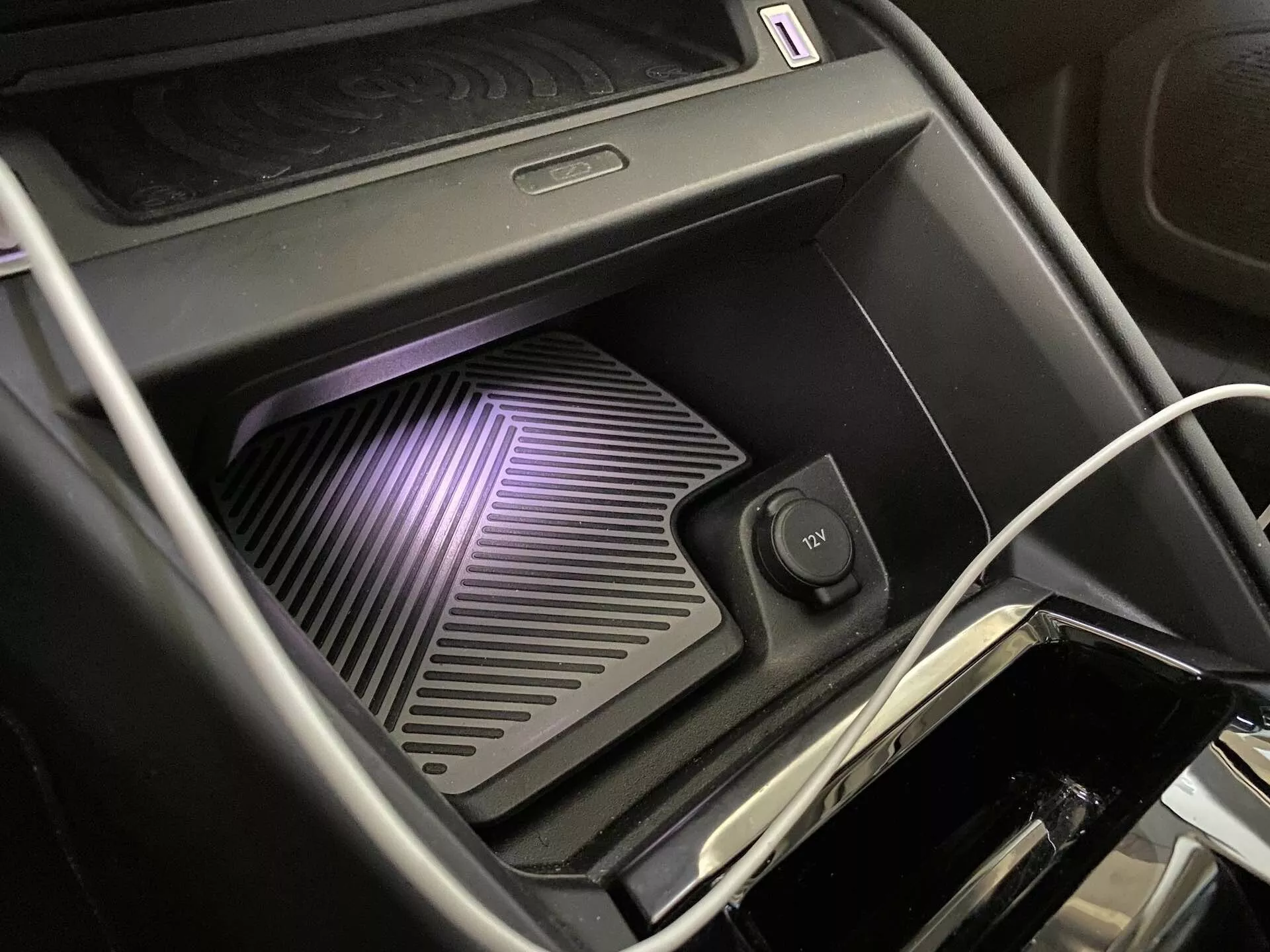 Citroen C4 2020 (e-C4) belső terének közelképe, amely a LED világítással ellátott, bordázott textúrájú vezeték nélküli töltőpadra és az extratartóra fókuszálva mutatkozik, vezetékes és vezeték nélküli töltési lehetőségekkel.