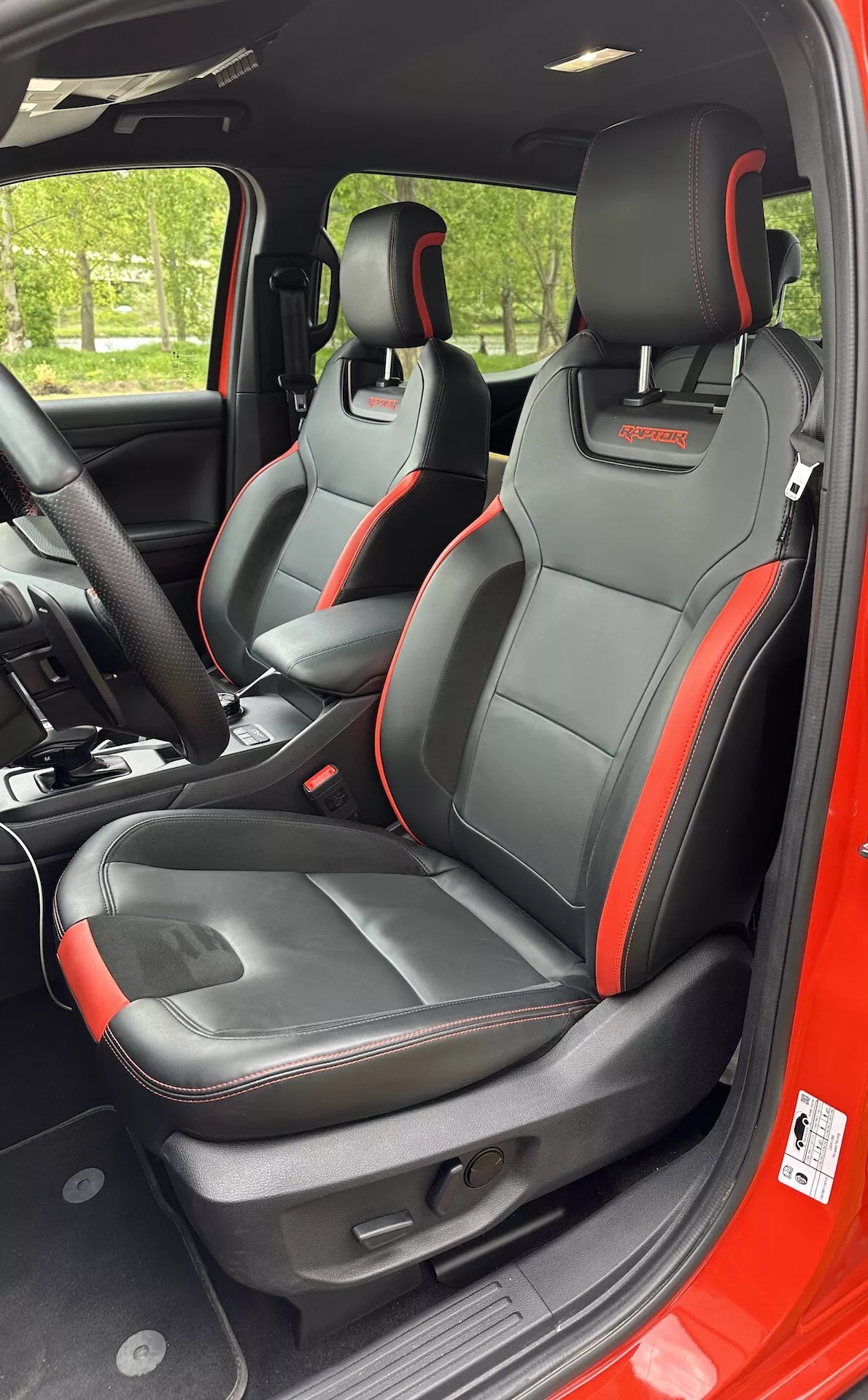 2022-es Ford Ranger belső nézet, sportos első ülésekkel, fekete és piros hangsúlyozó szegéllyel, integrált fejtámla funkciókkal és elektromos ülésállításokkal jobb oldali perspektívából