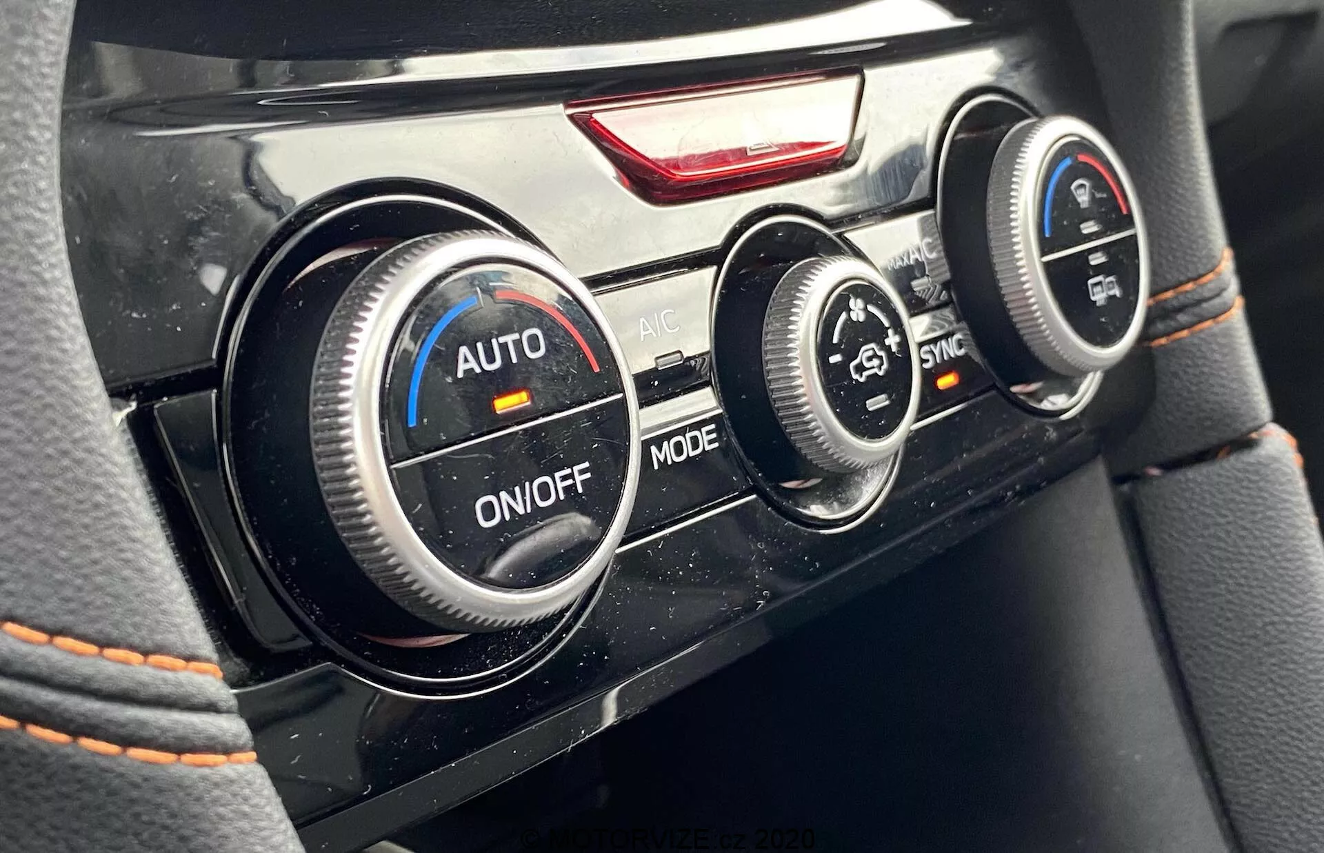 Közelkép a 2018-as Subaru XV klímavezérlő gombjairól az autó belterében. A vezető szemszögéből készült kép három kör alakú gombot mutat: a bal oldalit 