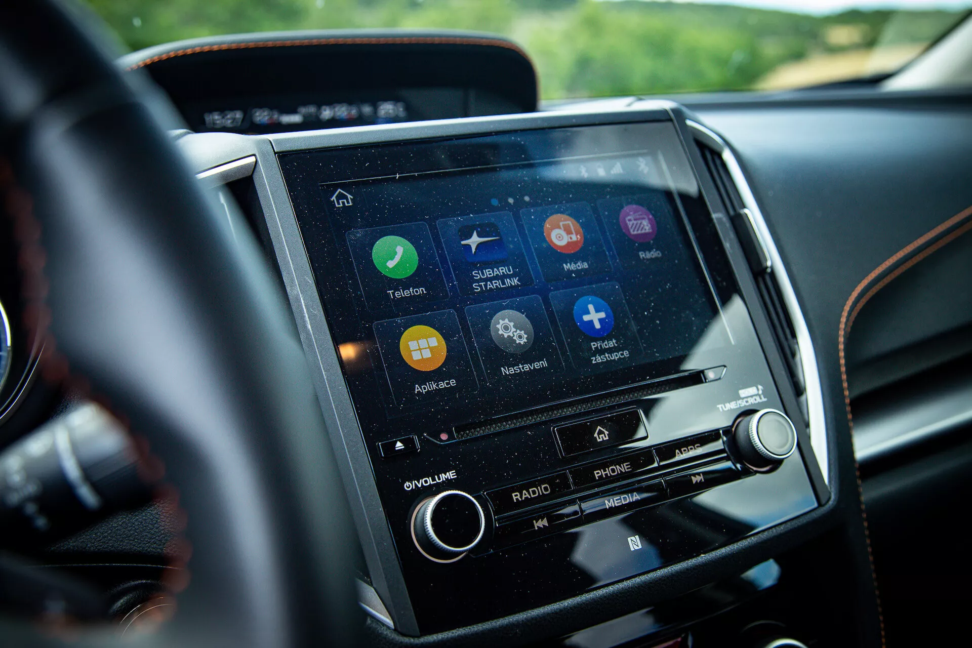 Közeli nézet a 2021-es Subaru XV középkonzolján elhelyezkedő érintőképernyős infotainment rendszerre a vezető perspektívájából, navigációs, telefon csatlakoztatási és zenei streaming alkalmazásokkal