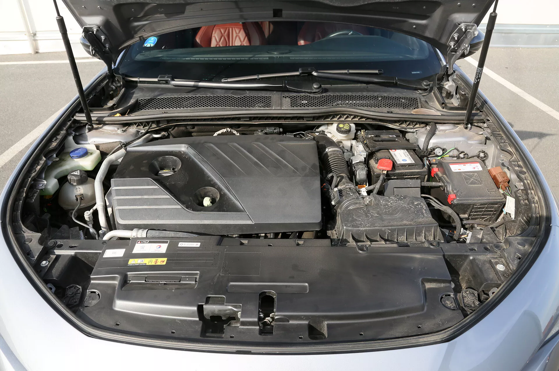 Részletes nézet egy 2001-es Toyota Camry Limuzin nyitott motorháztetőjéről, bemutatva a keresztben szerelt motort, az akkumulátort és a különböző motoralkatrészeket, a tervezésre és a karbantartásra összpontosítva.