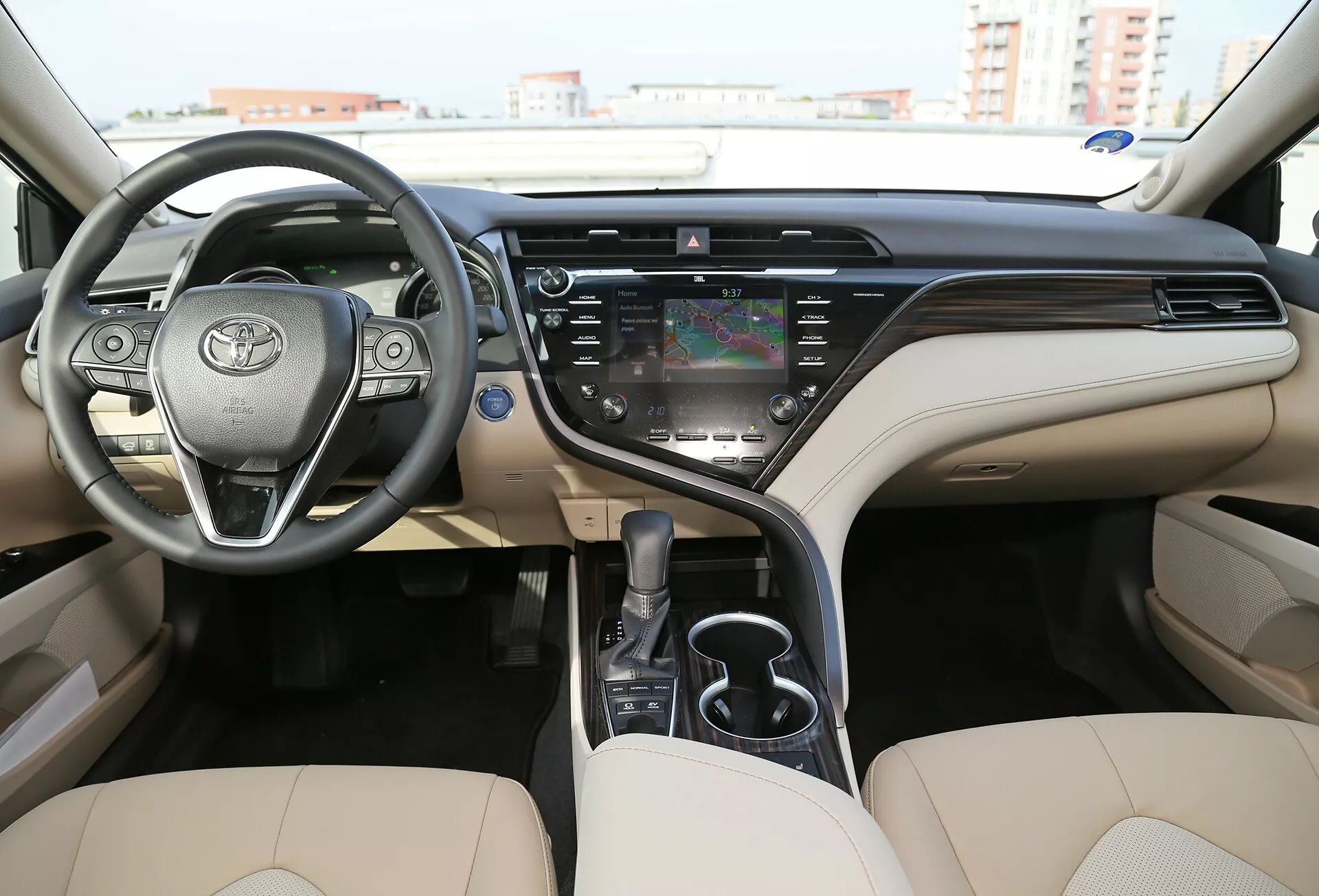 2001-es Toyota Camry limuzin belső nézete a műszerfalon, a beépített vezérlőkkel rendelkező kormányon és az első sor ülésein, két színű sémával, digitális és analóg összetevőkkel, központi érintőképernyős infotainment rendszerrel és prémium kivitel.