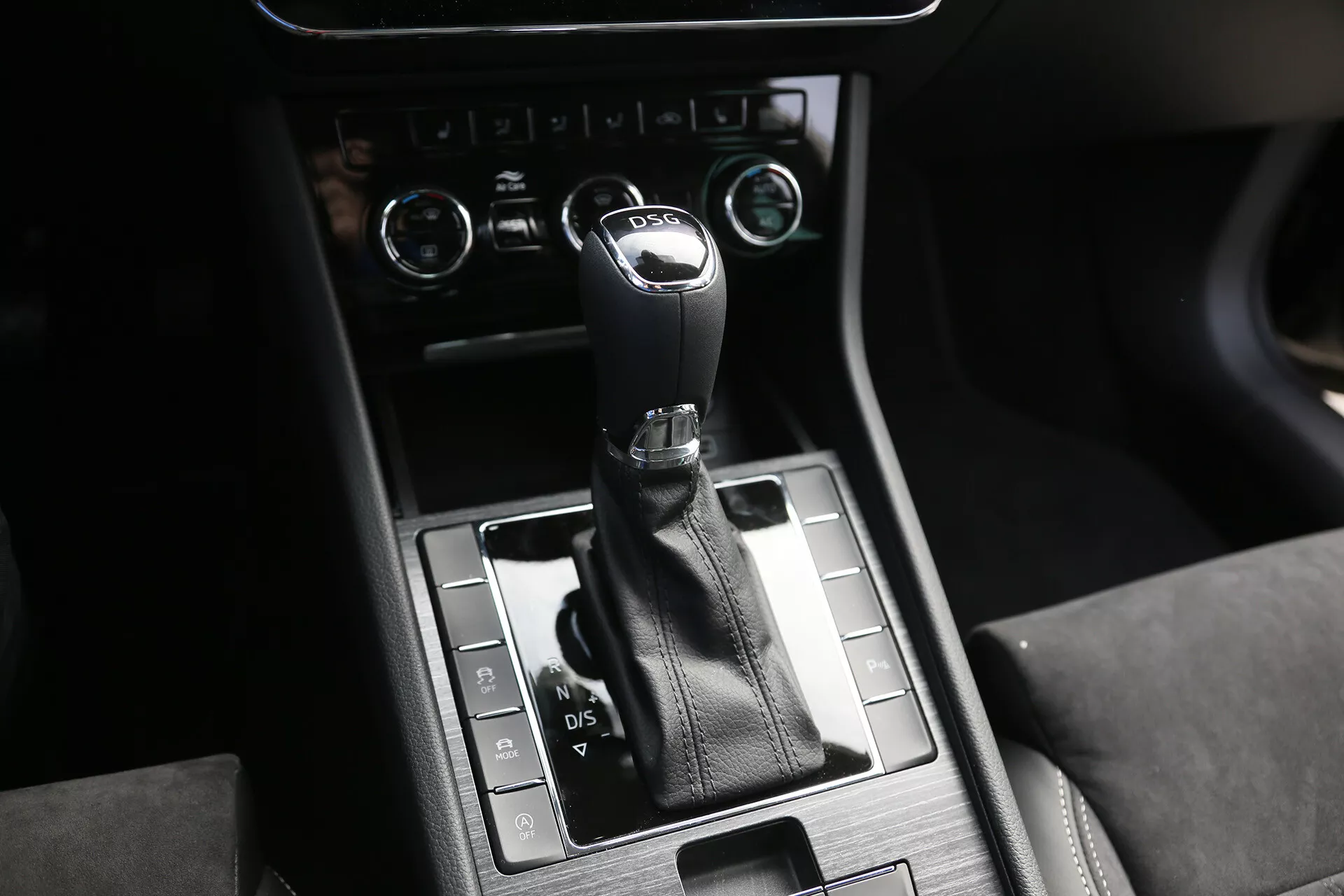 Közelkép a Toyota Camry 2001 középkonzoljáról automatikus váltókarral, P, R, N, D, S opciókkal fémes felületen, bőr részletekkel és klímakontroll gombokkal