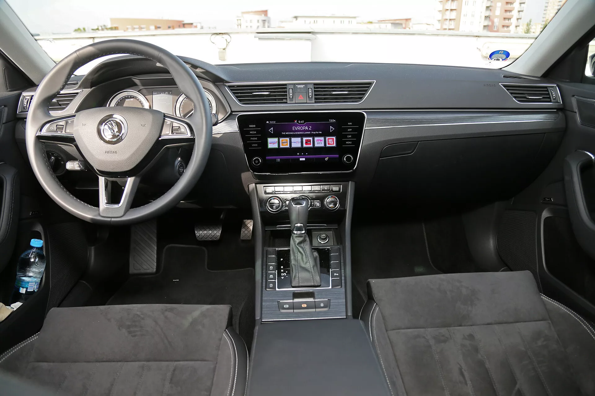 2001-es Toyota Camry limuzin belső terének bemutatása, amely a műszerfalat, a háromküllős kormánykereket integrált vezérlőkkel és a középkonzolt mutatja be, amely az infotainment rendszert és az automata sebességváltó váltókarját tartalmazza, hangsúlyozva az ambient és természetes világítást