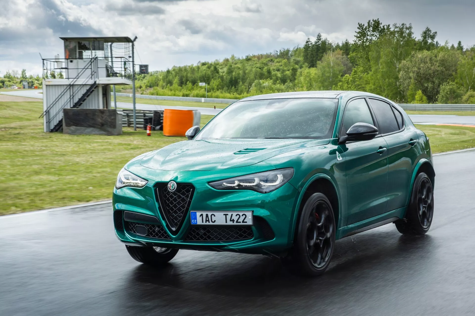 2023-as Alfa Romeo Giulia Quadrifoglio metálszínű vörösben, fejlett aerodinamikát, elegáns tervezést mutat be a jellegzetes V-alakú hűtőráccsal és bi-xenon fényszórókkal