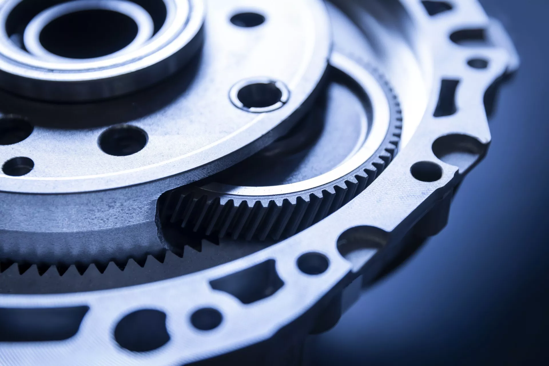 Pontos mérnöki tervezésű fogaskerék és fogasszíj-betét közelképe, valószínűleg autóipari használatra, finom megmunkálást és erőátviteli potenciált mutatva be hűvös ipari környezetben