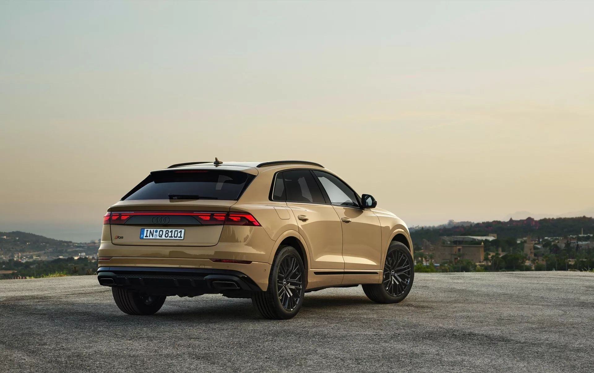 2023-as Audi Q8 (4M-Facelift) metál befejezéssel, panorámás kilátásnál parkoló, dombokkal és hajnal/szürkületi éggel, háromnegyedes hátsó szögletből látható design és funkciók
