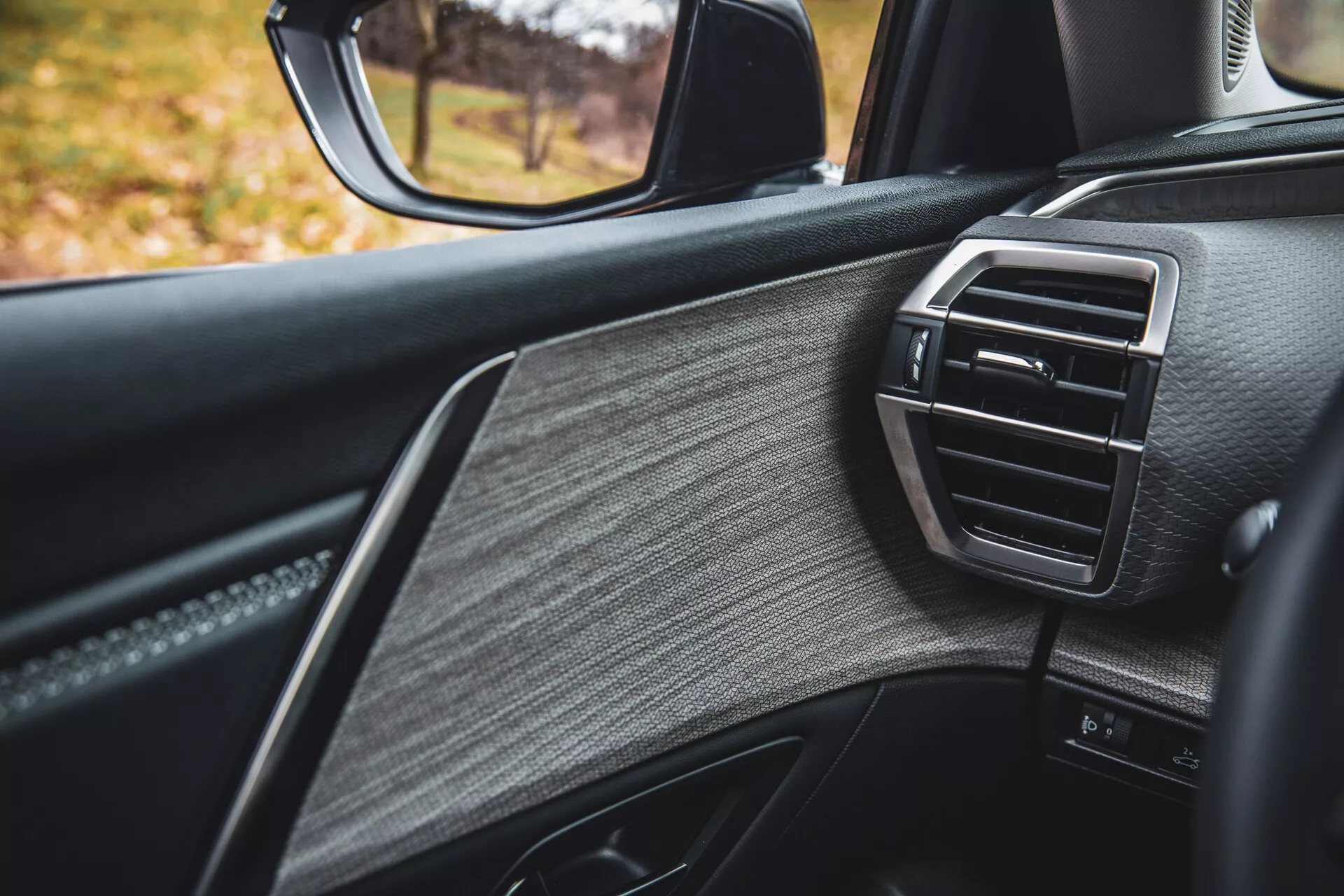 Részletes nézet a 2022-es Citroen C5-X utasoldali ajtójáról, amely luxus kialakítást mutat texturált bőrrel, fényes díszítéssel és klímavezérléses légterelővel