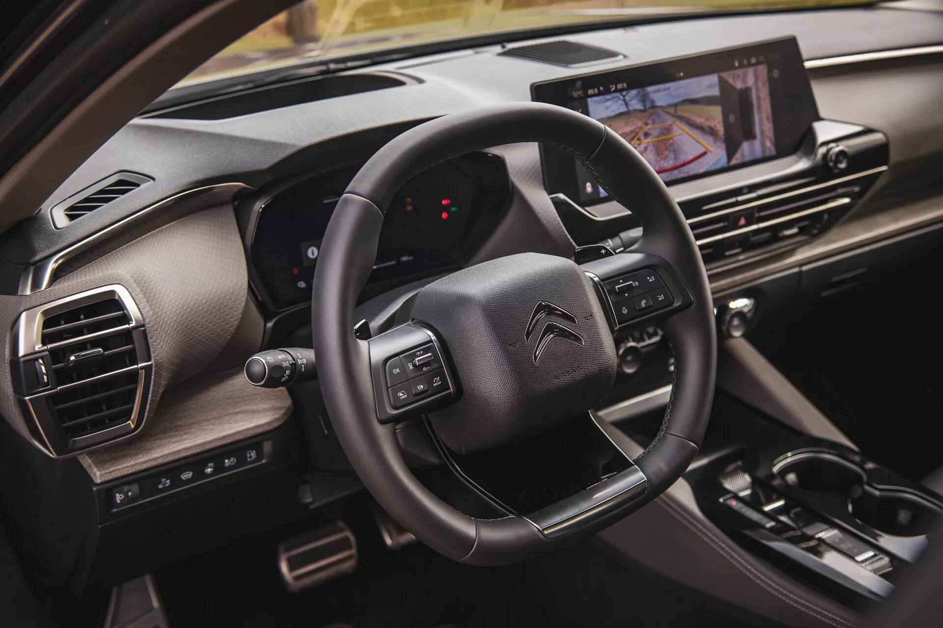 Citroën C5-X 2022 belső térközeli képe, amely a multifunkciós gombokkal ellátott kormányt, a digitális műszerfalat az utas perspektívájából és az érintőképernyős infotainment rendszert mutatja be