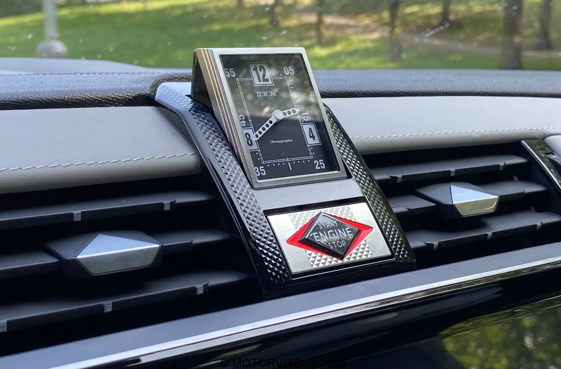 Közelkép egy DS-7 Crossback 2018 műszerfalába ágyazott, fényűző analóg óráról, amely kifinomult dizájnnal, római számokkal, fémes kivitelezéssel és gyémánt alakú logóval rendelkezik. A műszerfal szénszálas díszítésekkel és részletes varrással büszkélkedhet, hangsúlyozva a prémium autó belső tér magas színvonalú kidolgozását és fejlett anyagait.