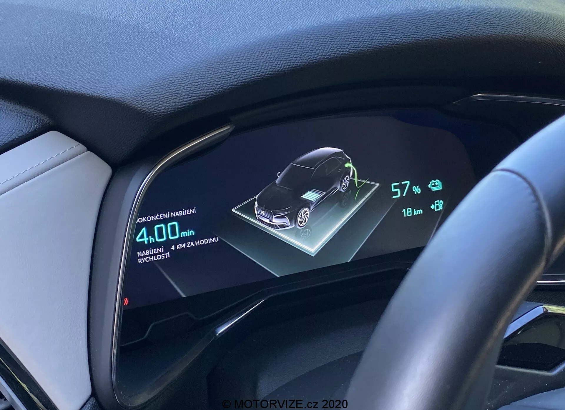 Digitalis műszerfal kijelzője egy DS Automobiles DS-7 2018-as (DS-7 Crossback) járműnek, amely a jármű 3D-s grafikus ábrázolását, az akkumulátor 57%-os állapotát, 18 km-es hatótávolságot és 4,0L/100km átlagos üzemanyag-fogyasztást mutatja, a vezető perspektívájából kormánykerékkel és bőrborítású műszerfallal.
