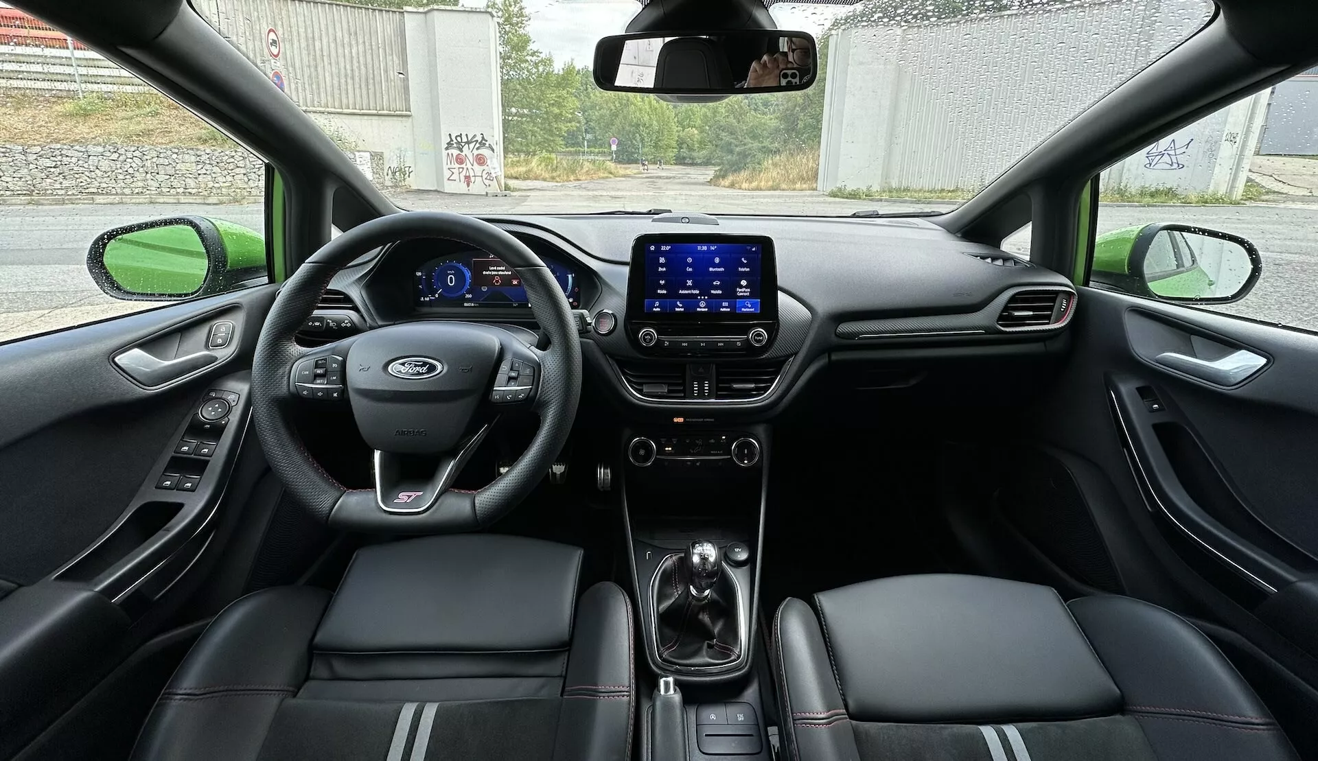 2022-es Ford Fiesta belső nézet a hátsó ülésből, bemutatva a teljes műszerfalat digitális műszerfalon, multifunkciós kormánykerékkel és varrott díszítésű bőrülésekkel