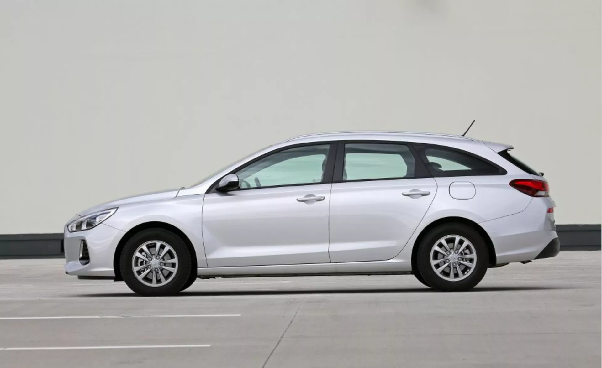 2017-es Hyundai i30-N kompakt ferdehátú oldalnézeti képe, amely kiemeli elegáns LED fényszóróit, oldalsó tükrökbe integrált irányjelzőit, aerodinamikai vonalait, ötvözött kerekeit, hosszú tengelytávját a növelt kényelem érdekében, és a látható kipufogócsövek hiányából kitűnő lehetséges hibrid vagy elektromos hajtásláncát, professzionális fotózási környezetben