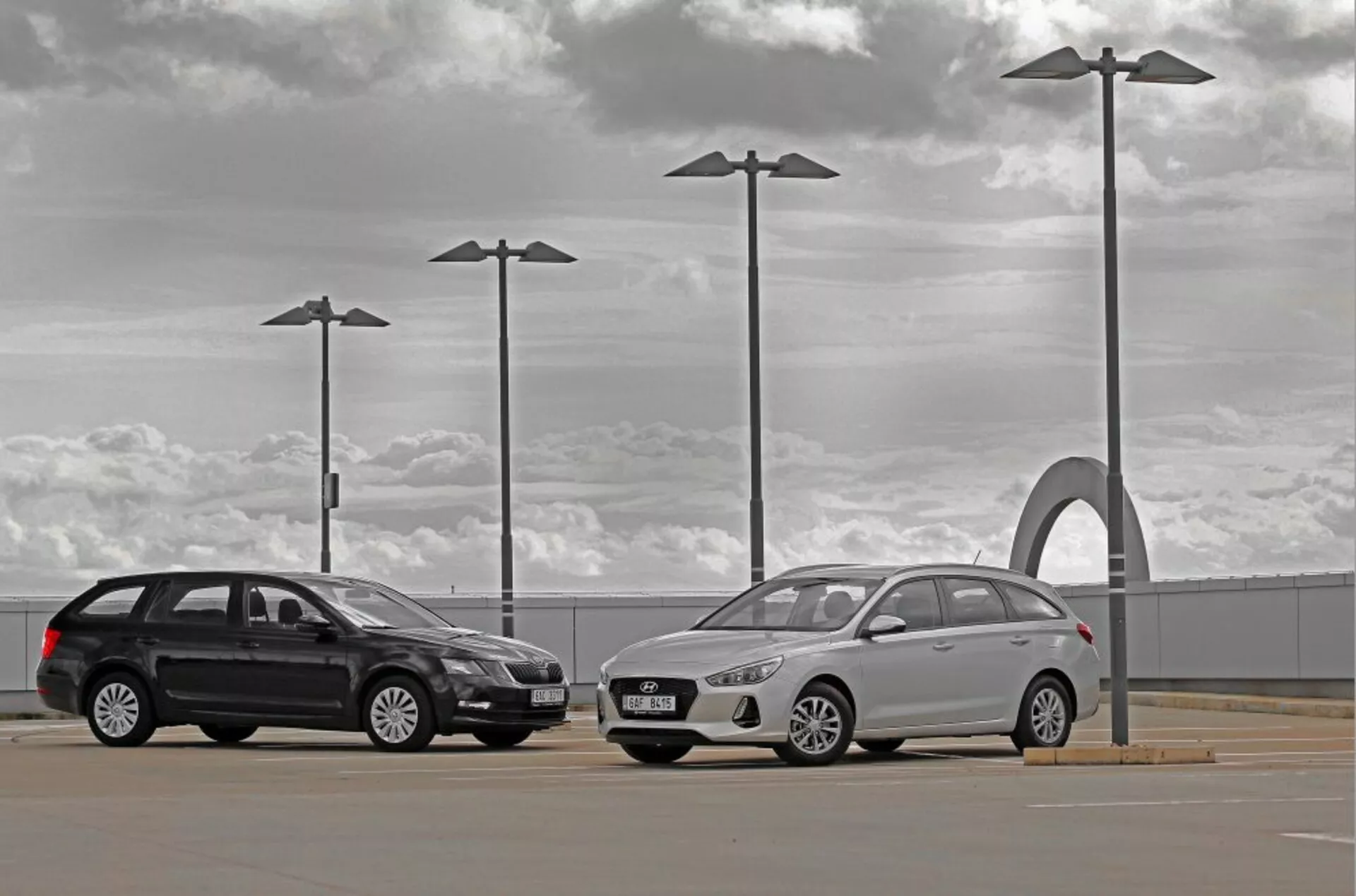 Hyundai i30 2017 kombi és szedán egy kültéri parkolóban felhős ég alatt, városi design elemekkel