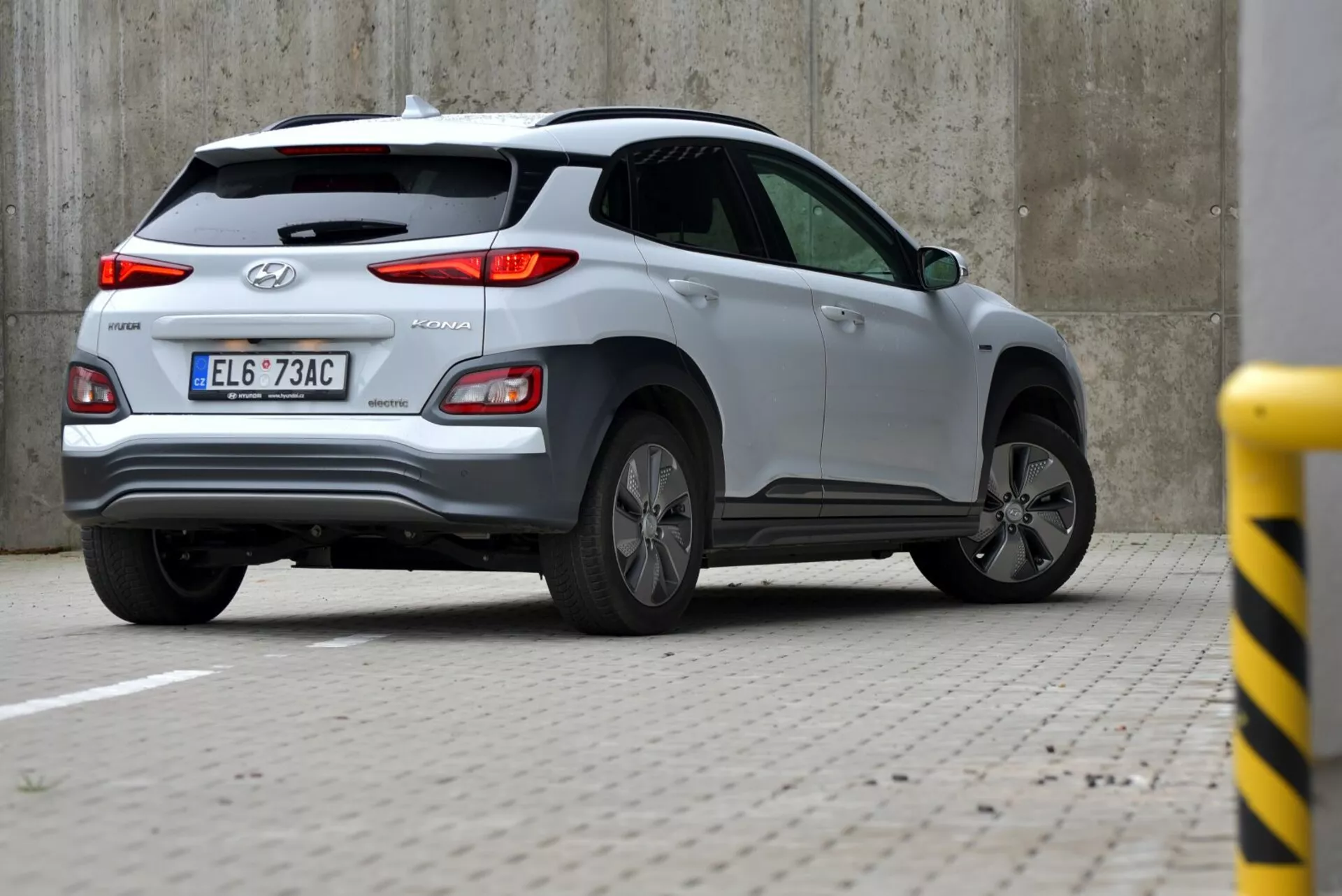 Ezüst Hyundai Tucson 2021 háromnegyedes hátulról nézetben, bemutatva a csomagtartót, a bal hátsó kereket és a jármű oldalsó részét a látható hátsó lámpával, Hyundai logóval és TUCSON felirattal, beleértve a hátsó szélvédő törlőjét, cápauszony antenna és ötvözetkerék tervezés.
