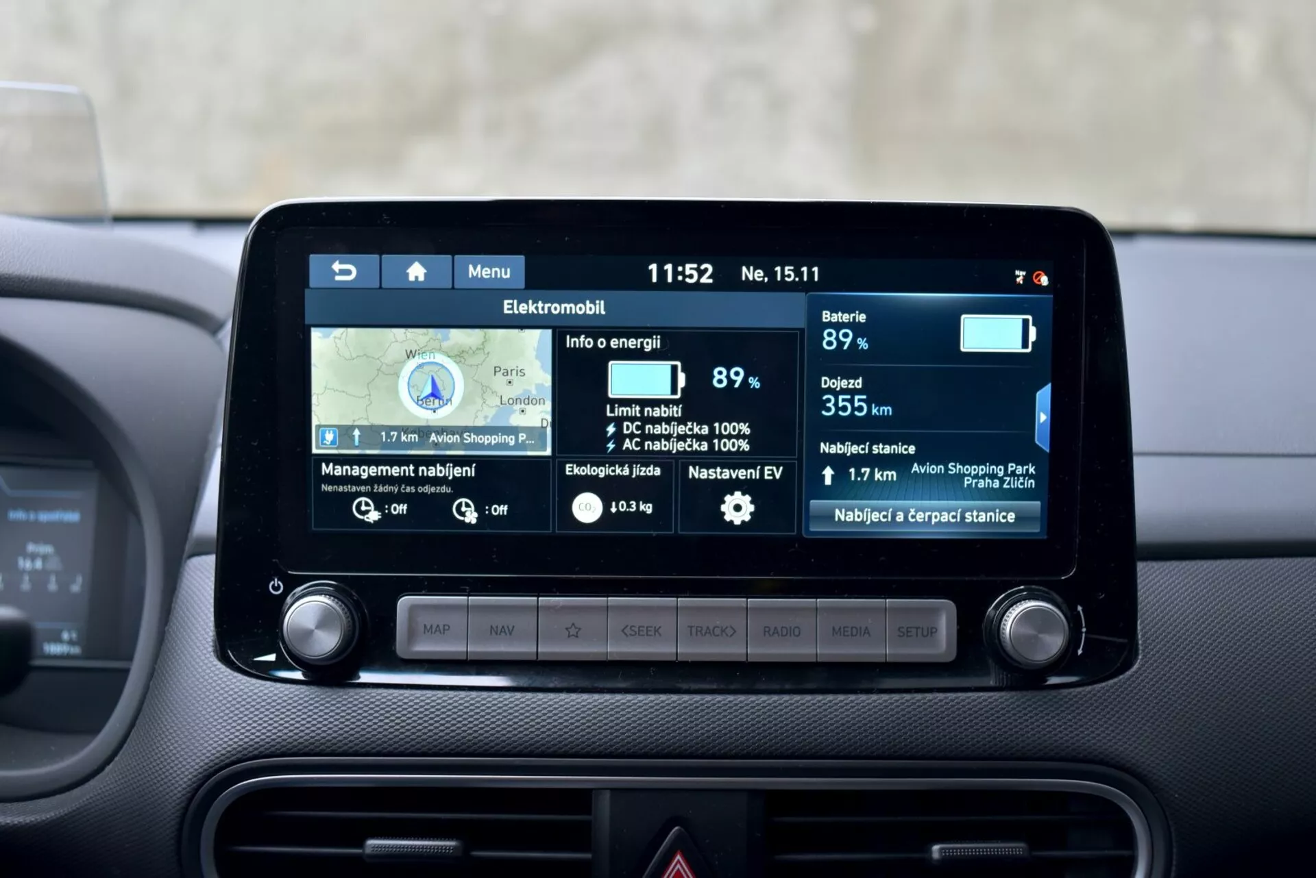 2021-es Hyundai Kona Elektromos belső tér, amely az infotainment rendszer kijelzőjét mutatja navigációs térképpel, az akkumulátor szintjével 89%-on, becsült 355 km-es hatótávval, idővel és külső hőmérséklettel egy elegáns műszerfalon