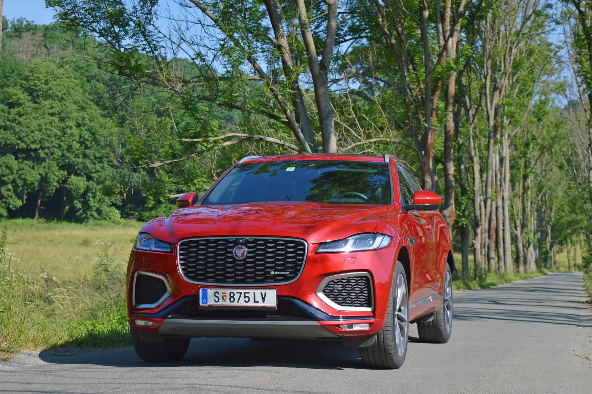 Jaguar F-Pace 2021 luxus SUV elegáns ezüst színben, dinamikus városi vezetés közben fényképezve, kiemelve a jellegzetes első hűtőráccsal, LED fényszórókkal és sportos alufelnikkel.