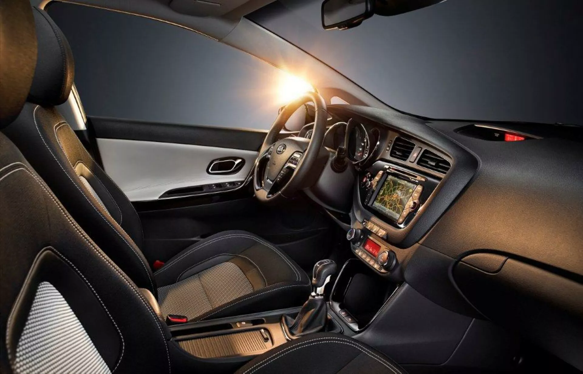 2009-es Kia Cee'd belső terét bemutató kép, amely a vezető oldalát, a bal oldali kormánykereket, műszerfalat, érintőképernyős infotainment rendszert, klíma vezérlőket, automata sebességváltót és modern design elemeket hangsúlyoz, kiemelve a technológiát, kényelmet és sportos megjelenést