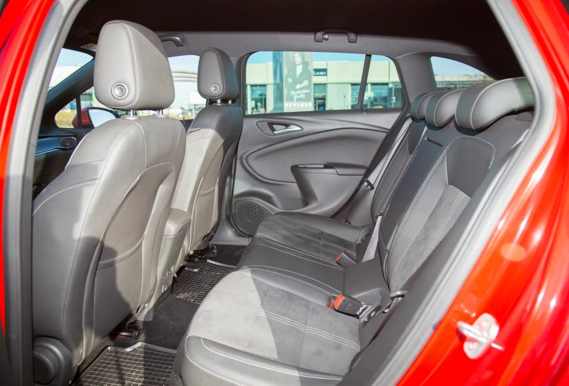 Közelkép a 2009-es Kia Ceed belső terének a vezető oldali hátsó ajtón keresztül nézve, kiemelve a kétszínű szövetkárpitozást és az ergonomikus üléskialakítást a fokozott kényelem érdekében