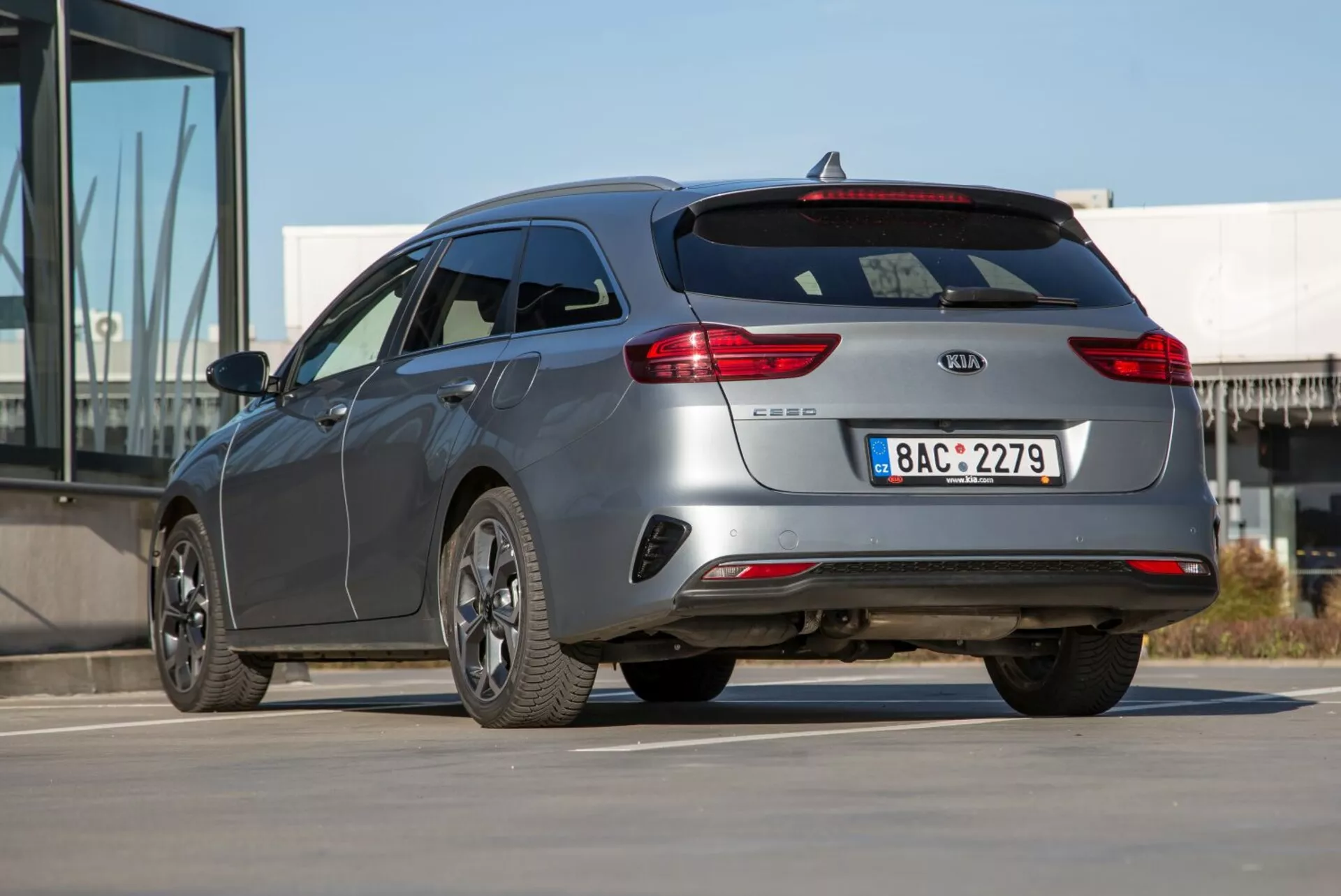 2009-es Kia Cee'd kombi háromnegyedes hátsó nézetben, amely bemutatja az elegáns görbületeket, a modern stílust, a csomagtér-ajtó spoilerét és a többsugaras ötvözetkeréket