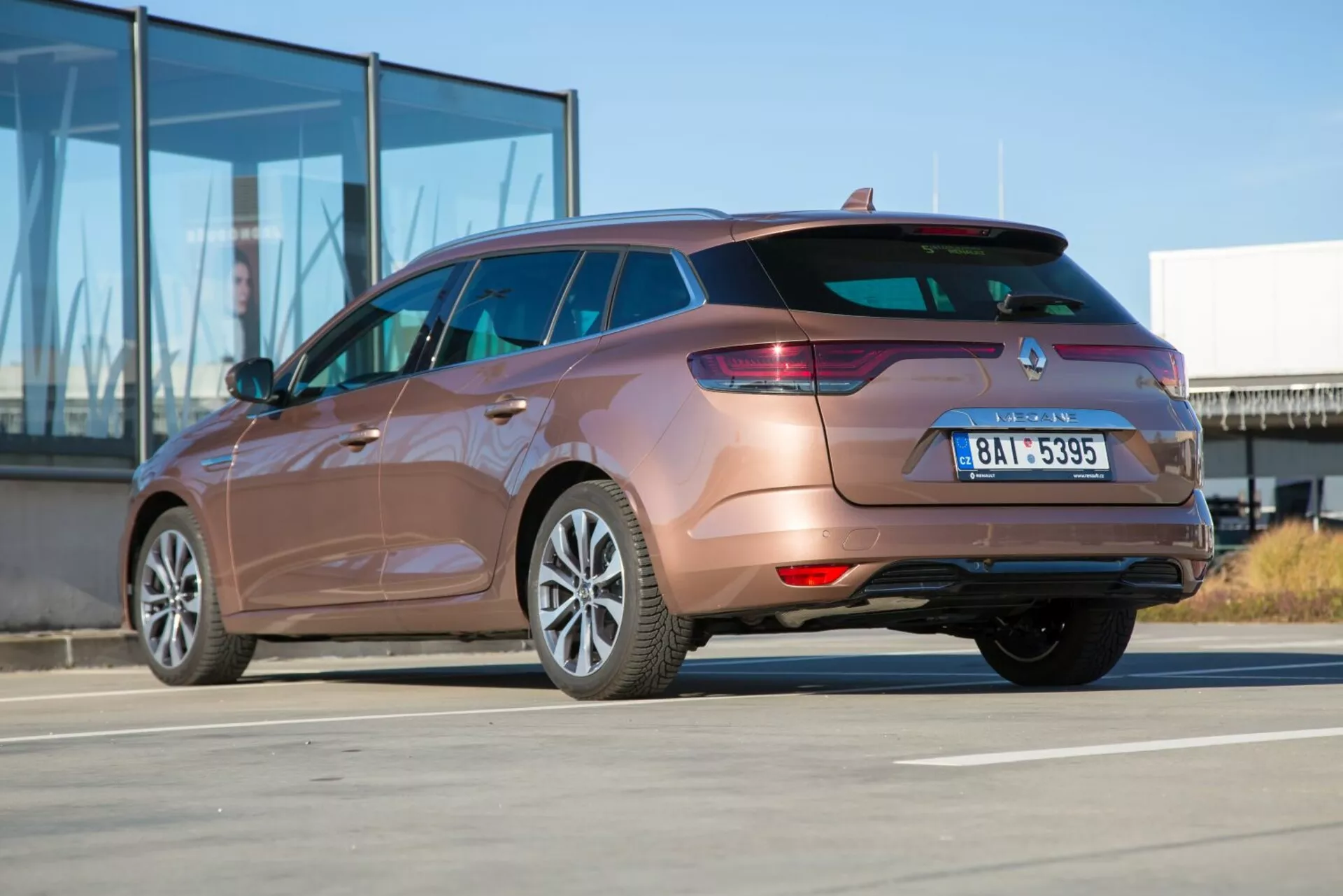 2009-es Kia Ceed kombi háromnegyedes hátulról látószögből, kiemelve a hátsó lámpákat, a hátsó lökhárító tervezését, a kipufogócsövet és az oldaltest kontúrjait napos napon