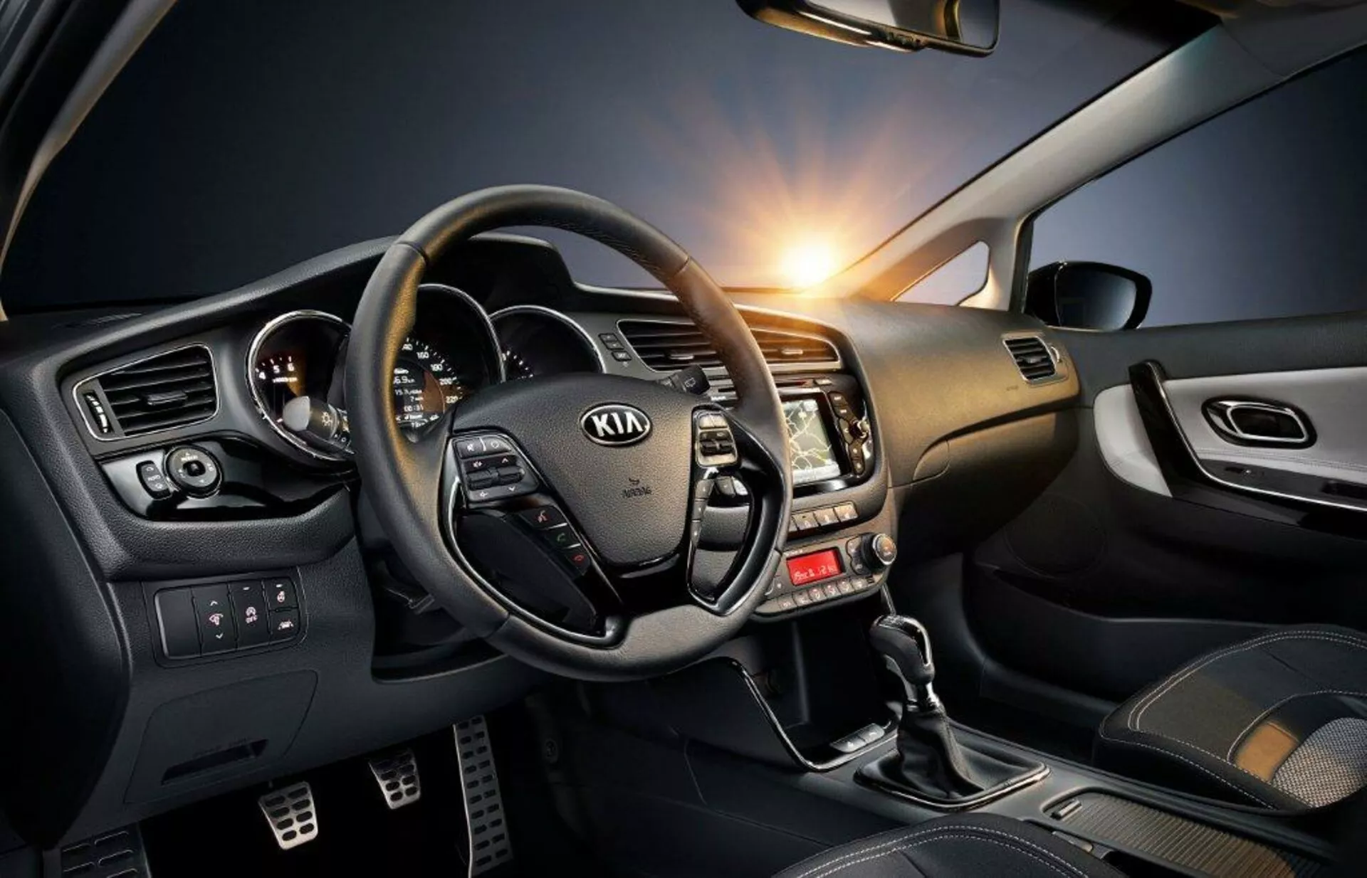 2009-es Kia Ceed belső vezetőfülkéjének nézete, amely kiemeli a kormánykerékkel ellátott vezérlőgombokat, a fémes hangvételű műszerfalat és a technológiában gazdag sofőr oldalát, beleértve a sebességváltó karját, az elektromos ablakok vezérlőit és a hangulatvilágítást.