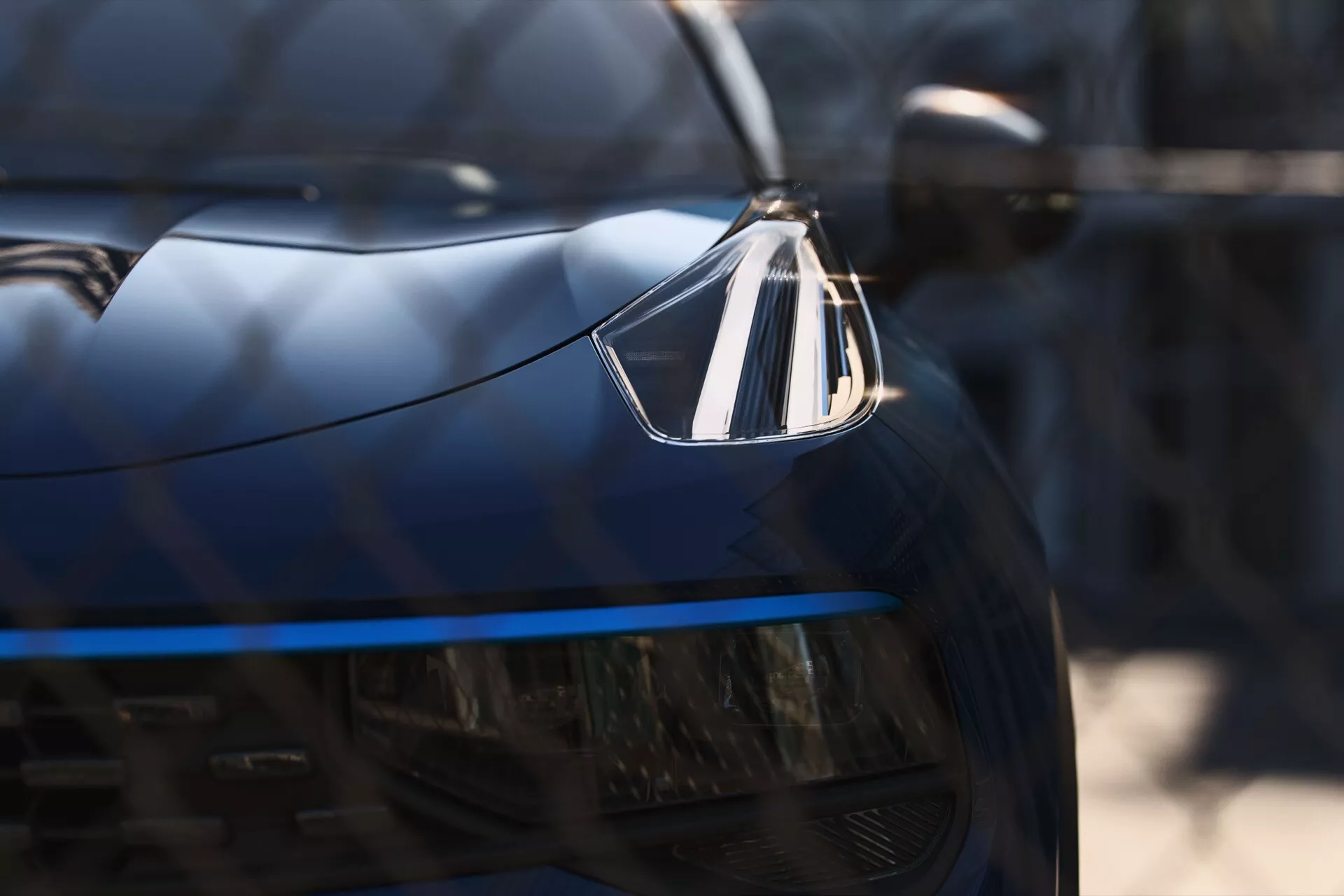 A Lynk & Co 01 2021-es modelljének fényszórója és hűtőrácsa közeli nézete, LED világítást és luxuscímkét bemutató, bal első perspektíva