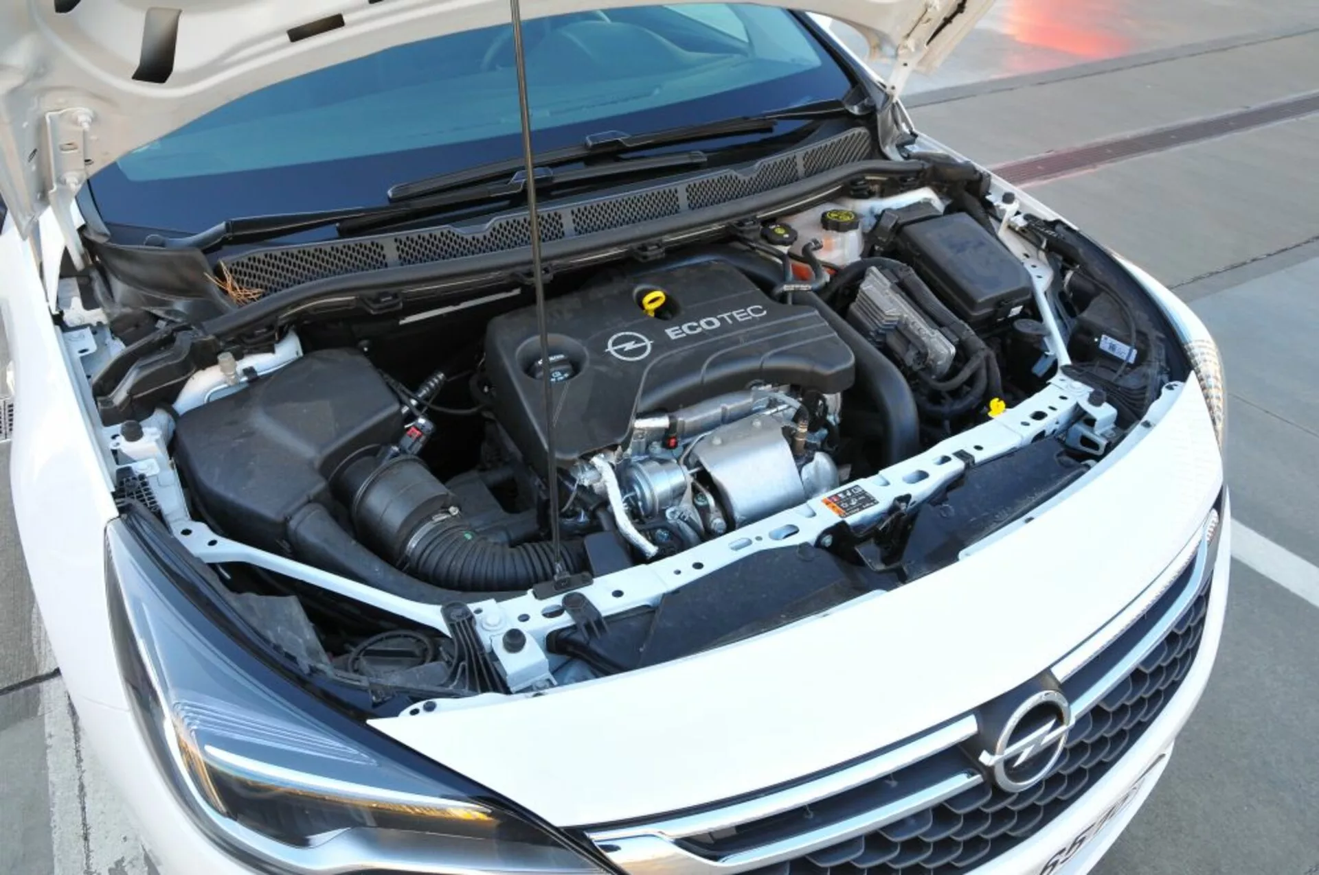 Felülnézeti kép az Opel Astra 2005 Ecotec motoros részére, bemutatva a motorblokkot, a légszívó tömlőt és különböző alkatrészeket