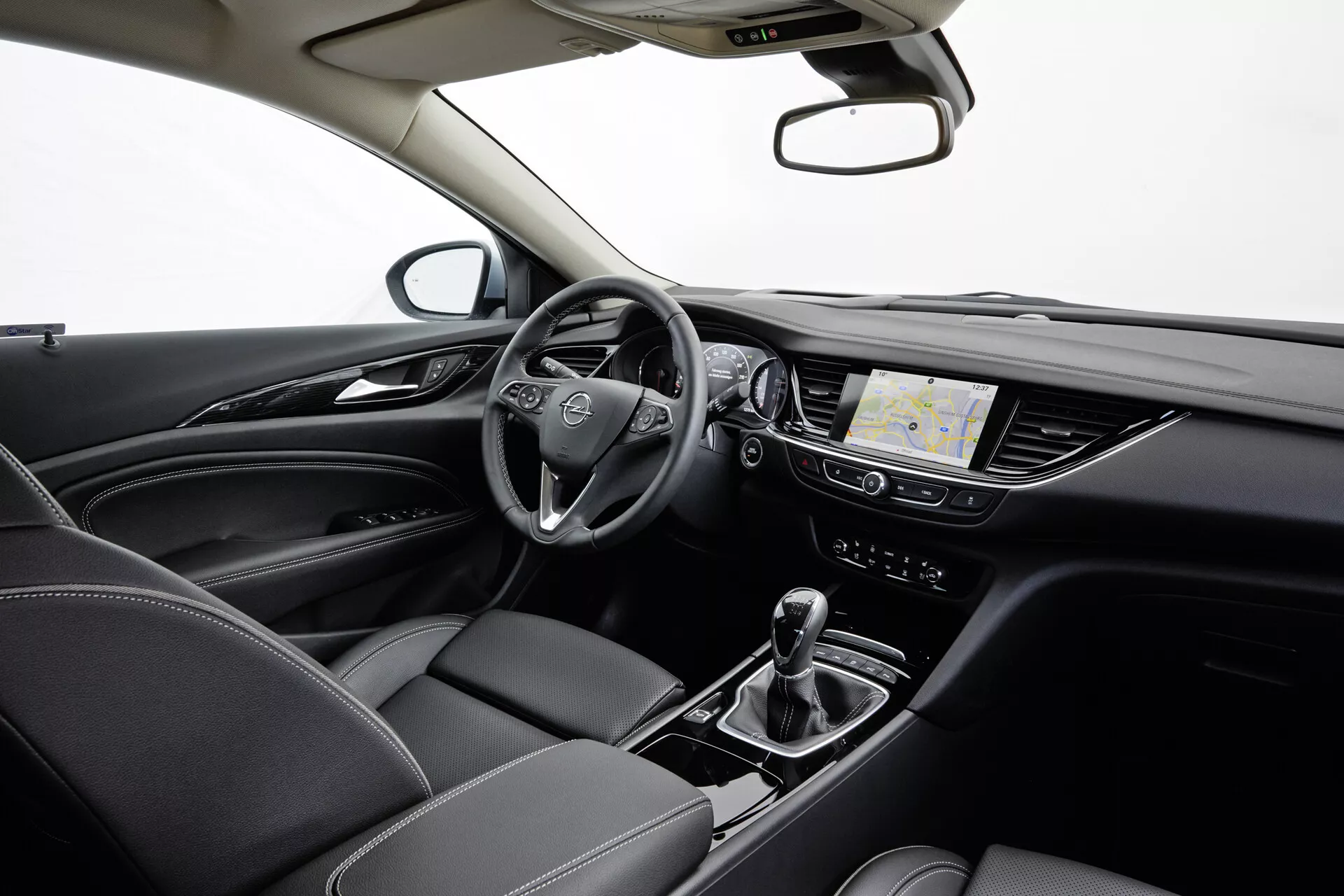 Opel Insignia 2013 belső terét bemutató többfunkciós kormánykerék, digitális műszerfal, érintőképernyős infotainment rendszer navigációval, automatikus váltó vezetési mód választóval, klímavezérlés és részletesen varrott bőrülések, mindez profi stúdió világítás alatt.