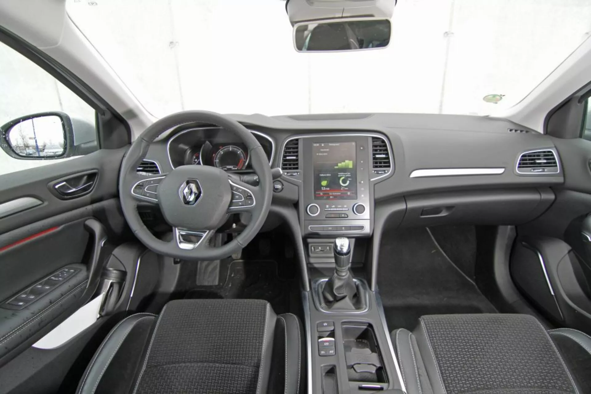 2013-as Peugeot 308 SW belső terét ábrázolja, amely a gyártó emblémájával ellátott kormánykereket, a beépített navigációs rendszerrel ellátott fedélzeti műszerfallal, klíma vezérlőkkel, fémes díszlécekkel, automatikus sebességváltó karjával, mintás szövet ülésekkel, és vezetőközpontú kezelőszervekkel mutatja be, speciális technológiai jellemzők nélkül