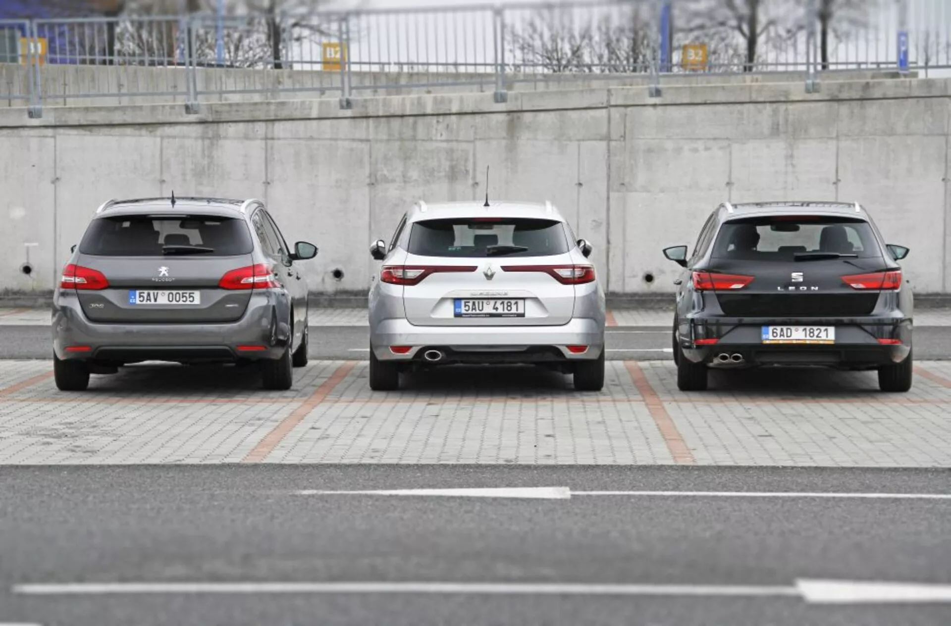 Három Peugeot 308 SW 2013 autó egymás mellett parkolva, bemutatva a hátsó design-t beleértve a hátsó lámpákat, lökhárítókat és rendszámtáblákat városi parkoló környezetben