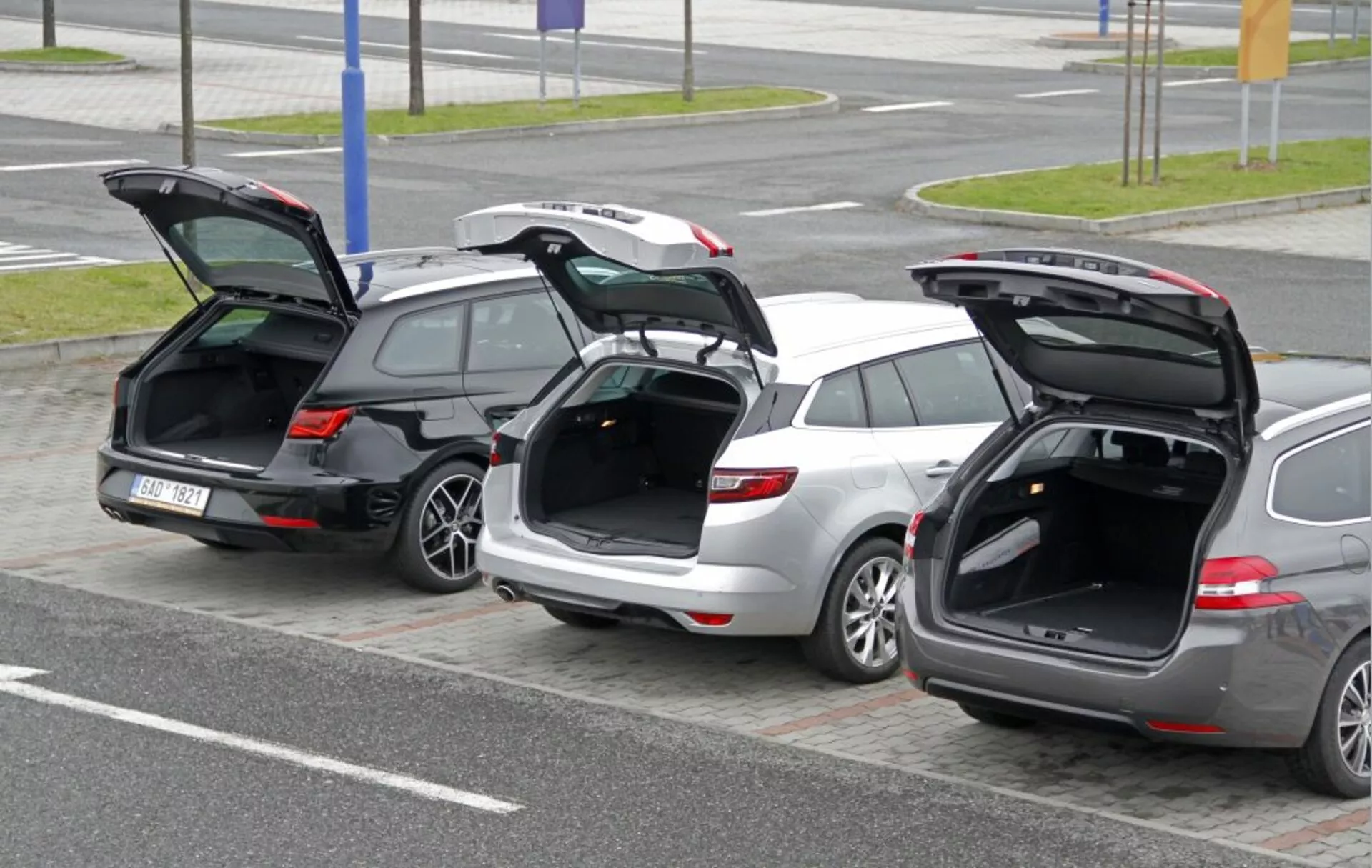 Három Peugeot 308 SW 2013 kombi sorakozik egymás mellett nyitott hátsó ajtókkal, amelyek kiemelik a rakodóteret és a csomagtartó ajtajának tervezését emelt szemszögből