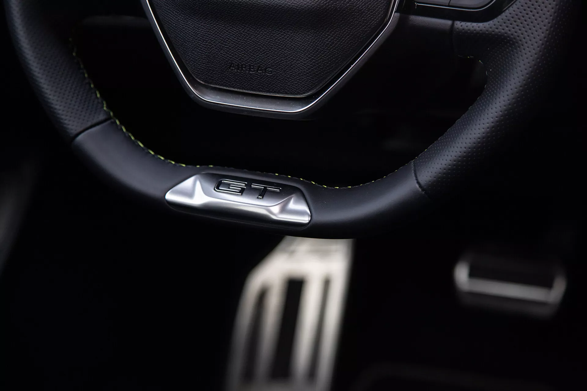 2023-as Peugeot 408 belső tér, sportos, bőr- vagy bőrszerű anyagú, GT emblémás kormányra, fémből készült teljesítménypedálokra és prémium sötét utastér jellemzőire összpontosítva