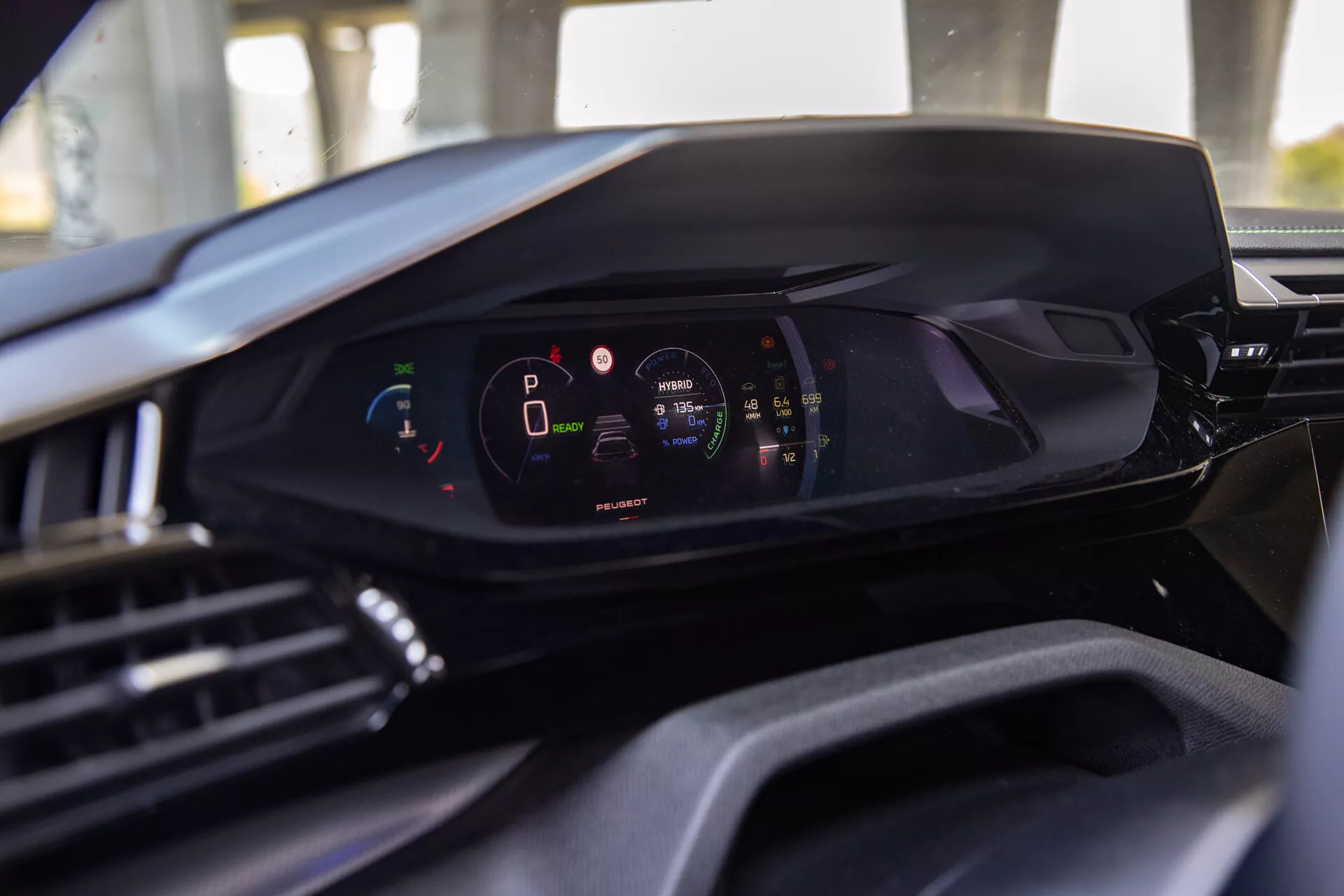 2023-as Peugeot 408 belső nézete, amely bemutatja a modern digitális műszerfalat a vezetőülés perspektívájából, kiemelve a digitális műszerclustert a járművel parkoló módban és magas akkumulátortöltöttségi szinttel