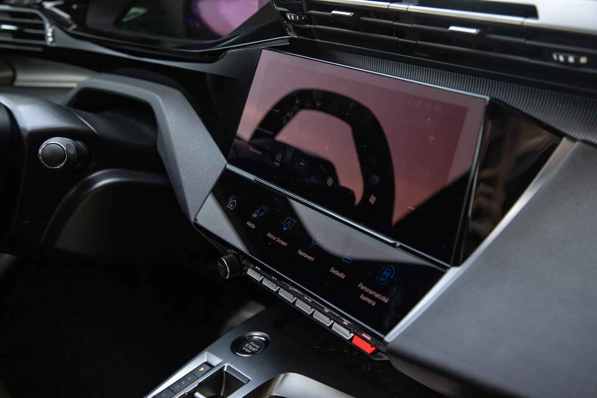 2023-as Peugeot 408 belsőtere, amely bemutatja a középkonzolt és a fejlett infotainment rendszert érintőképernyővel, klíma vezérlő gombokkal és elegáns tervezési akcentusokkal