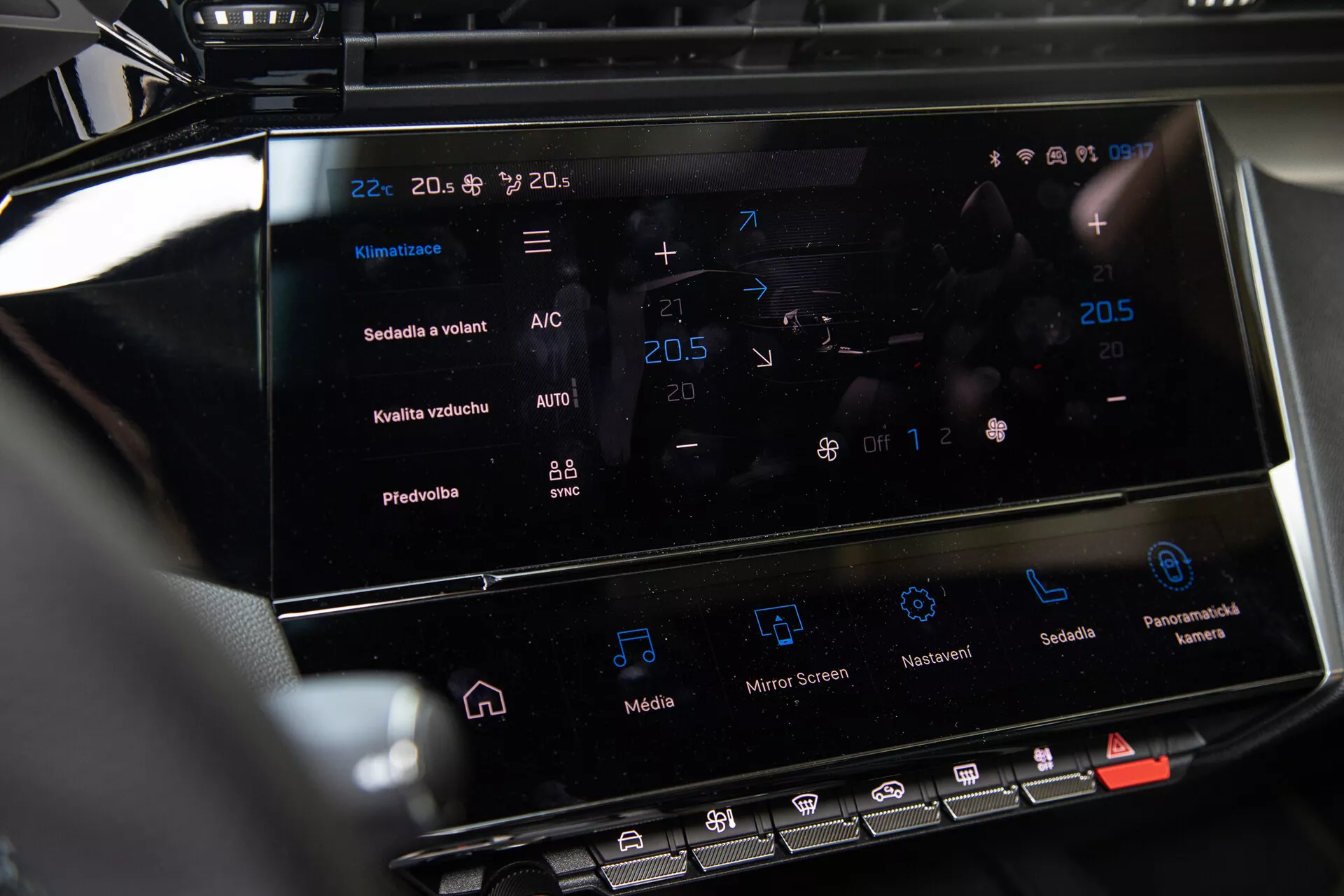 2023-as Peugeot 408 középkonzolja, amely az érintőképernyős infotainment rendszert és a klímavezérlő interfészt mutatja a hőmérséklet-beállításokkal és fejlett funkciókkal