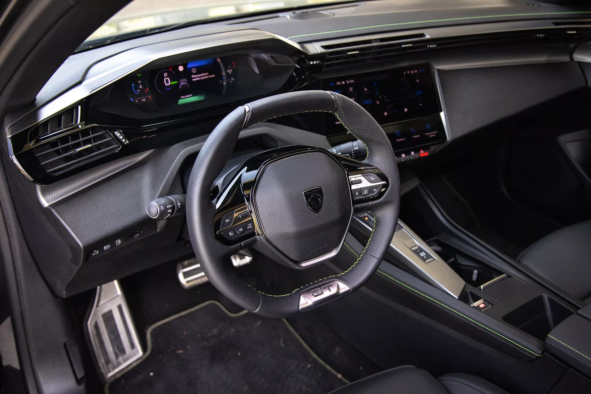 2023-as Peugeot 408 belső tere, mely bőrbevonatú, multifunkciós kormánykereket, digitális műszerfalat, széles érintőképernyős infotainment rendszert és sportos, prémium dizájnelemeket mutat természetes napfényben az első utas nézőpontjából.