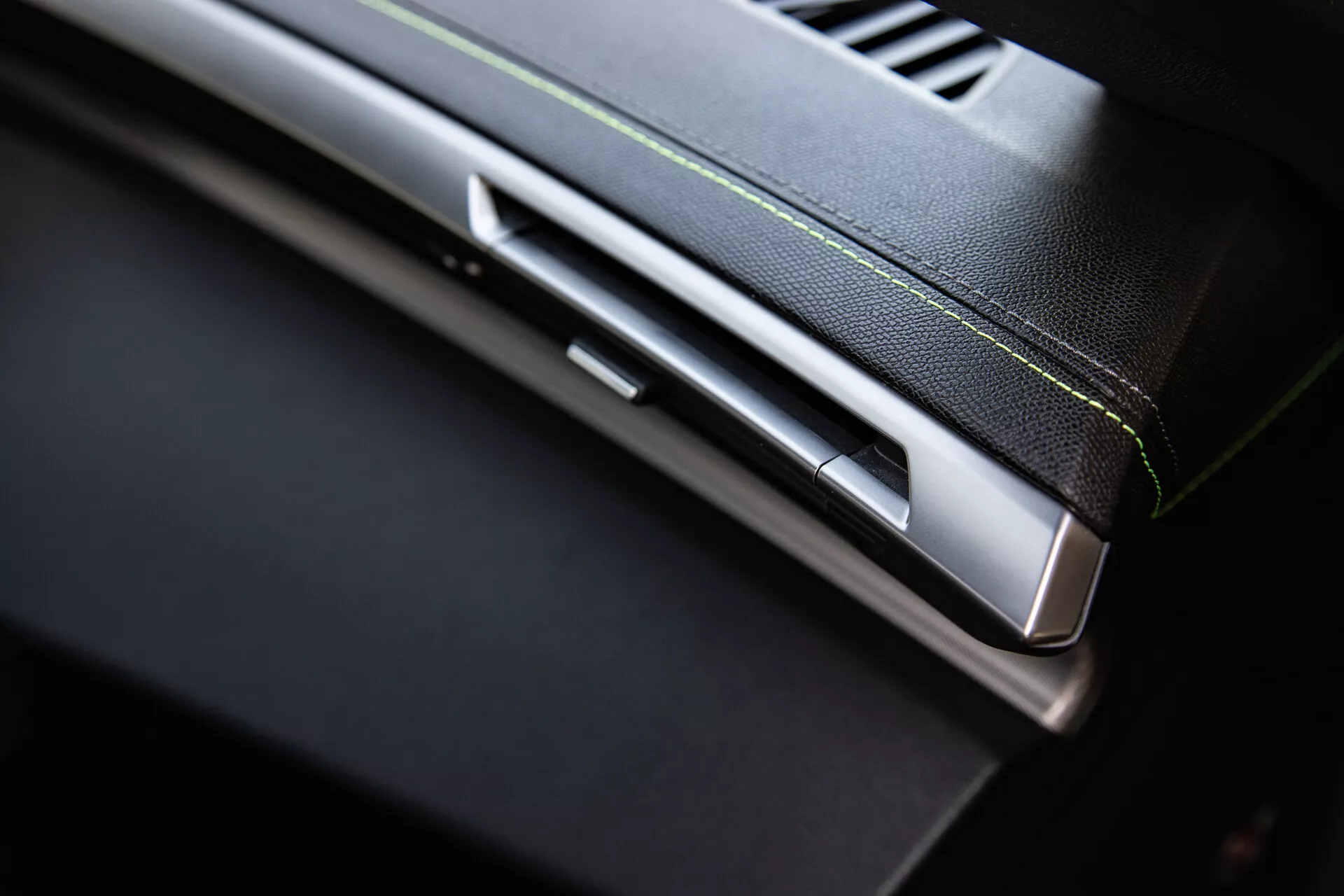 Közelkép a Peugeot 408 2023-as modelljének interiőrjéről, részletezve a műszerfalt a légkondicionáló nyílással, fémes díszléccel, vezérlő csúszkával és magas minőségű, kontrasztos varrással ellátott kárpitozással