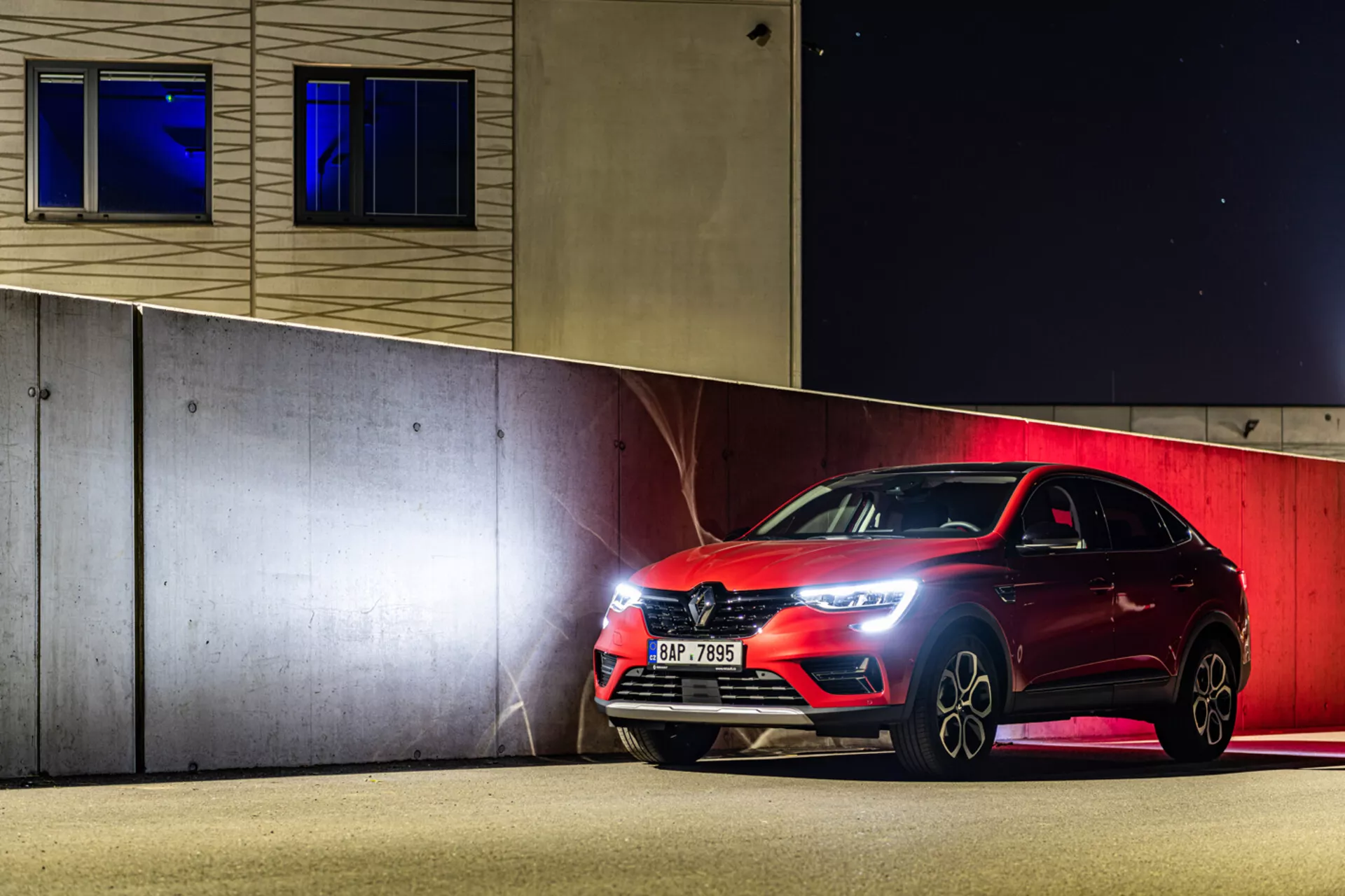 2021-es Renault Arkana sportos hatchback éjszaka parkol, bemutatva a LED fényszórókat, az első hűtőrácsot és az ötvözött kerekeket mesterséges világítás alatt