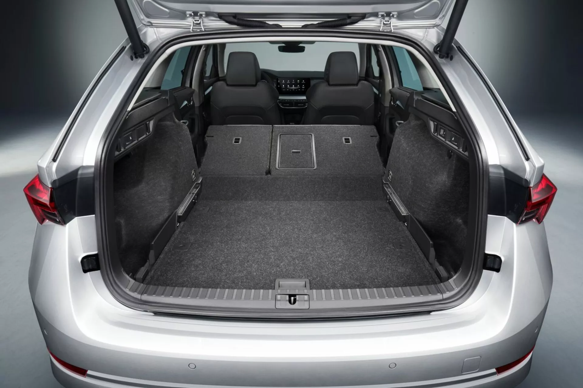 2017-es Skoda Octavia liftback nyitott csomagtartójának megjelenítése, amely tágas raktérrel, lehajtott hátsó ülésekkel, lapos rakodópadlóval, szőnyegborítással, rögzítési pontokkal a biztonságos tárolás érdekében, és lehetséges haladó technológiai jellemzőkkel, mint az LED világítás