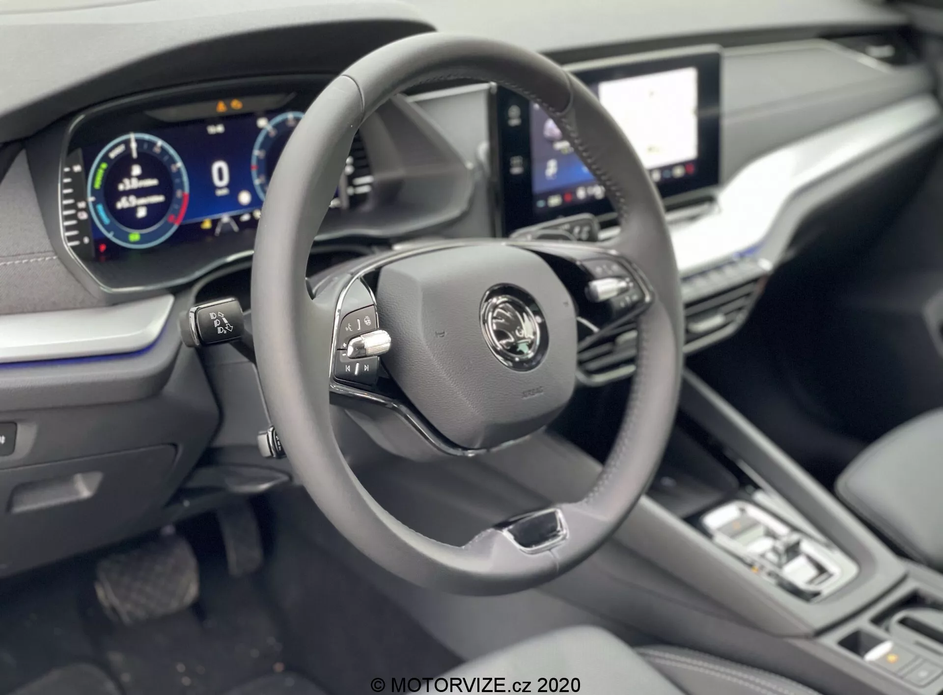 2020-as Skoda Octavia Limousine belterének bemutatása a vezetői területre fókuszálva egy enyhén megemelt szögből, amely egy modern háromküllős kormánykereket mutat többfunkciós gombokkal, központi gyártói logóval és egy teljesen digitális műszerfallal 0 km/h sebesség kijelzéssel. A látható funkciók közé tartozik egy nagy infotainment érintőképernyő, minimalist klímavezérlő gombok és tárcsák, automata sebességváltóra utaló váltókar, bőrbevonatú kormánykerék, bőrkárpitozás és króm díszítőelemek a prémium érzés érdekében