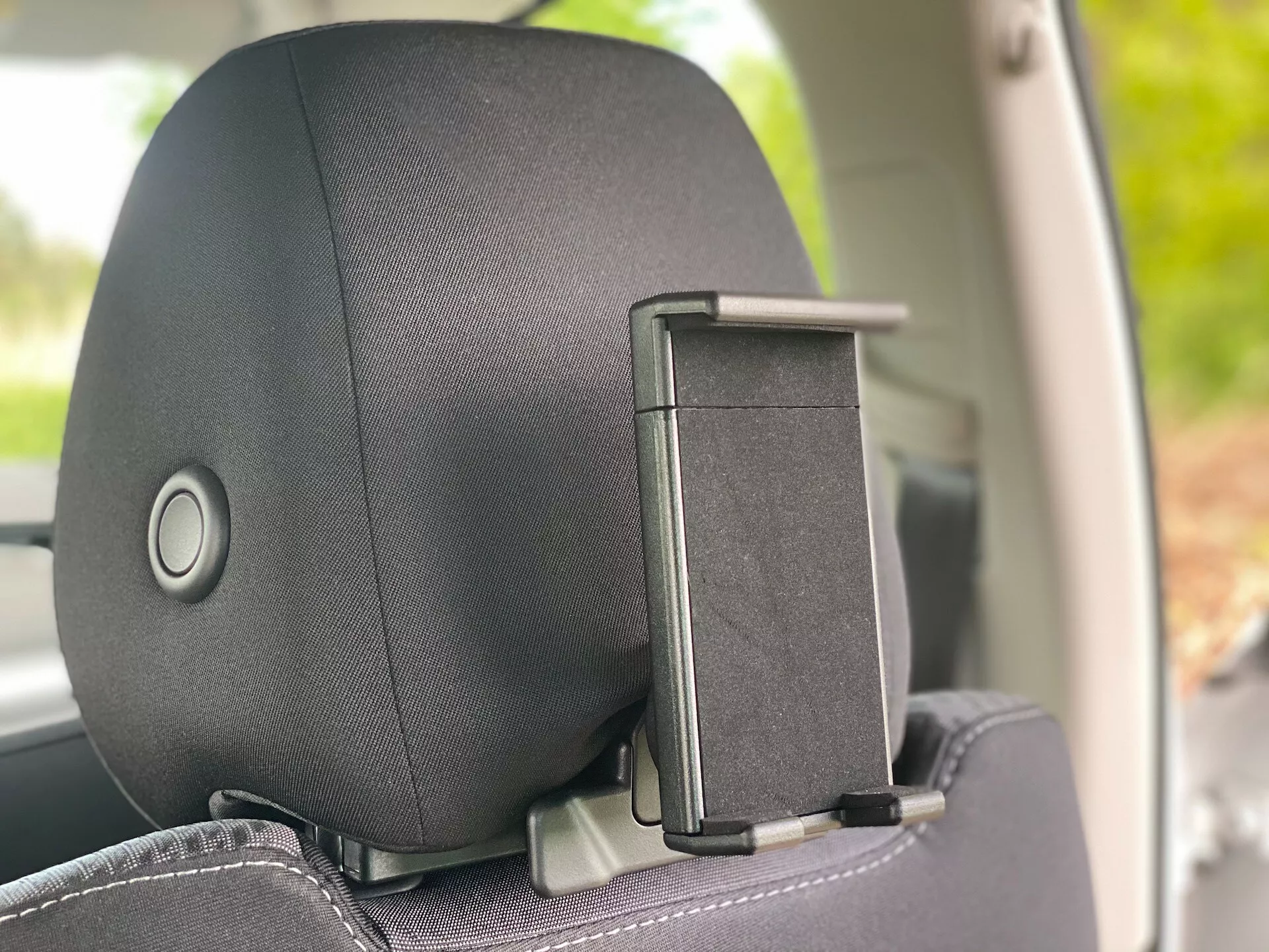 Közeli nézet egy Škoda Octavia 2020 (Octavia-Limousine) fejtámlájáról egy belső oldalsó szögből, kiemelve a fejtámla állító mechanizmust és a kabáttartót. A fejtámla szövet vagy bőr borítással rendelkezik egy finom mintával, a kényelemre és a dizájnra összpontosítva.