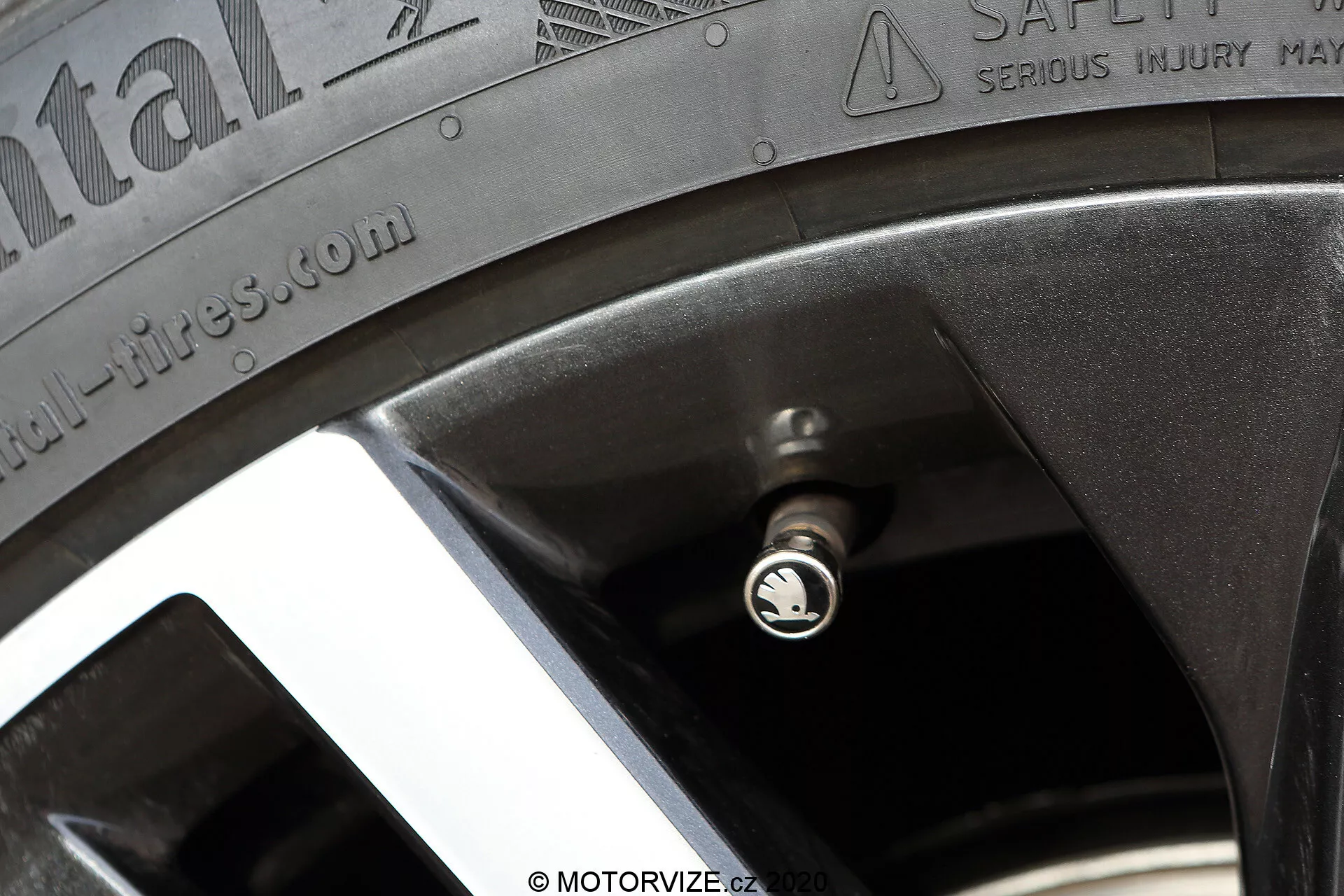 Közelről oldalnézetben egy Skoda Octavia 2020 kerekének részlete, látható Continental ContiSportContact abronccsal, az oldalfal szövegével és az alufelni peremével. A kép kiemeli a gumiabroncs specifikációit, mint például a maximális terhelés és nyomás figyelmeztetéseit, növelve az autó teljesítményét és biztonságát.