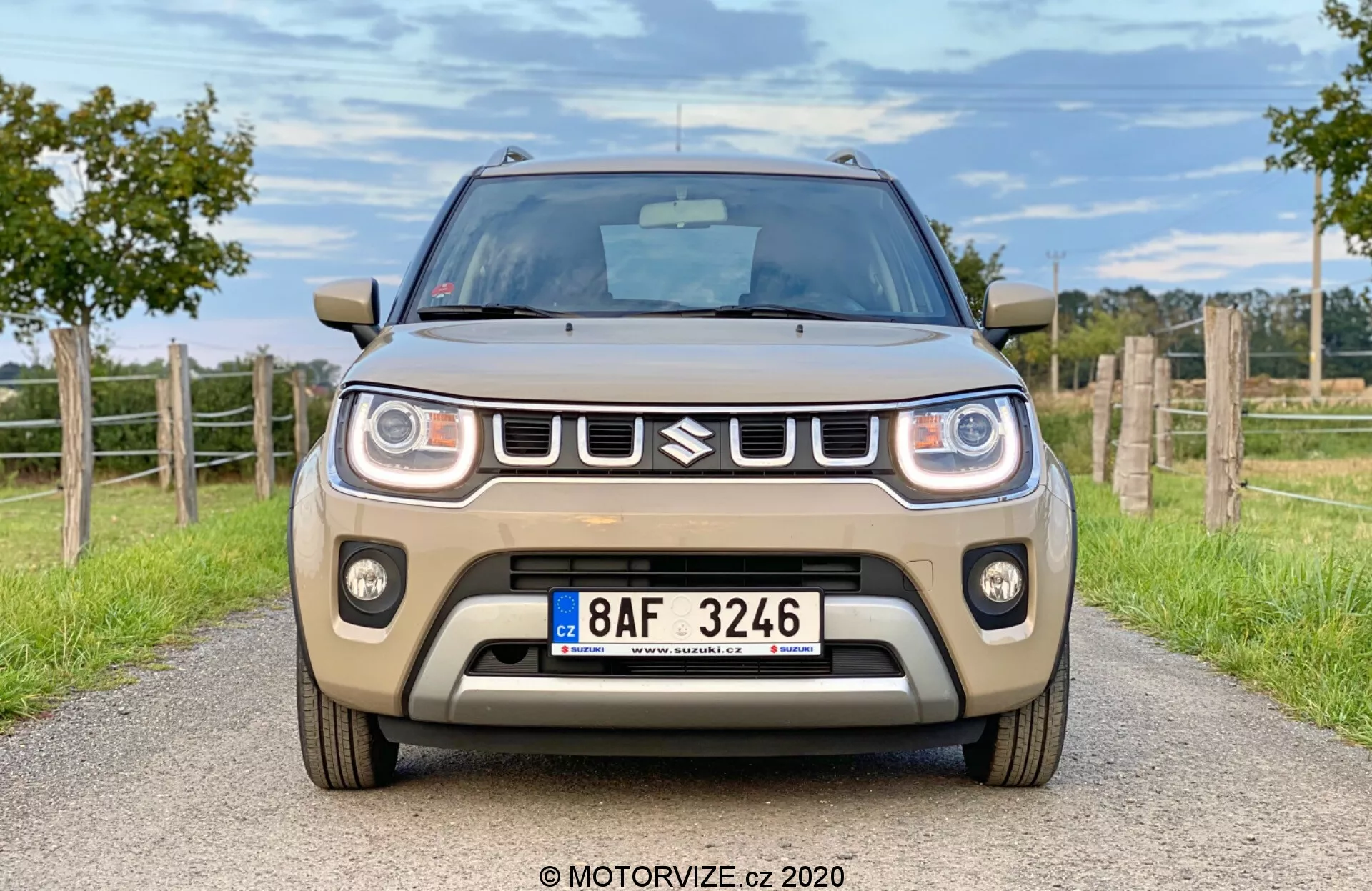 A 2020-as Suzuki Ignis 1.2 Dualjet Hybrid Club elölnézeti és oldalnézeti képe városi környezetben, kiemelve a kompakt dizájnt, a modern fényszórókat és a merész hűtőrácsot.