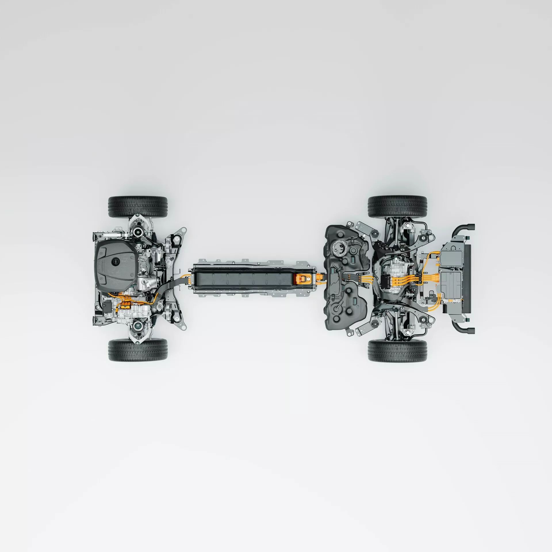 Légifelvétel egy szétszerelt elektromos jármű (EV) alvázáról, kiemelve a kulcsfontosságú technológiai jellemzőket, beleértve a négy különálló kereket felfüggesztési összeszerelésekkel, egy központi magasfeszültségű akkumulátorcsomagot, az elektromos motorokat és a hajtásrendszer elemeit a két végén, valamint a látható narancssárga magasfeszültségű kábeleket. Az elrendezés egy összkerékhajtási rendszert sugall, semleges háttérrel, amely tiszta, illusztratív módon hangsúlyozza az alkatrészeket.