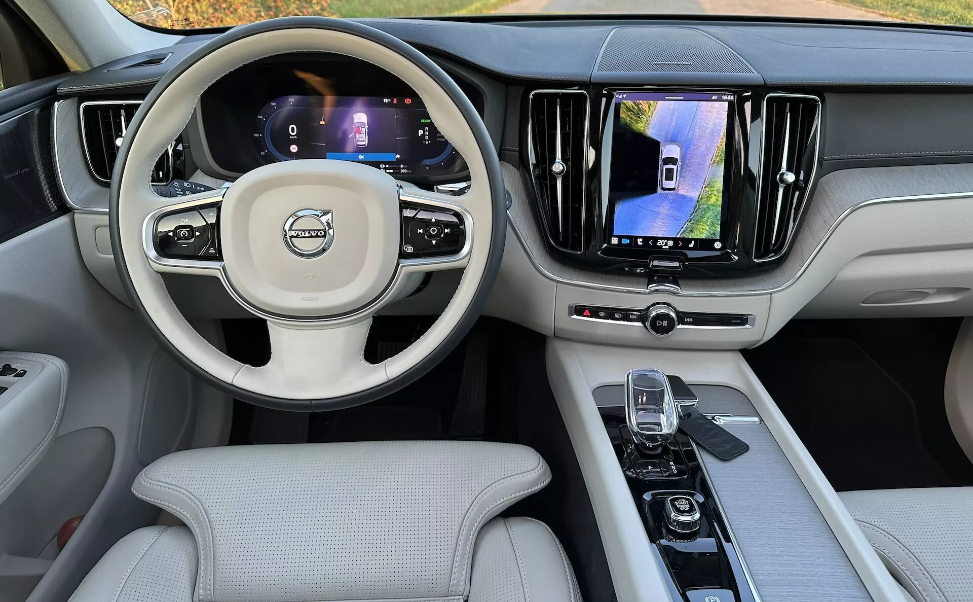 2021-es Volvo XC60 Recharge Plug-in Hybrid belső nézete a hátsó ülésekből, bemutatva az műszerfalat, digitális kijelzőket, multifunkciós kormányt és a középkonzolt