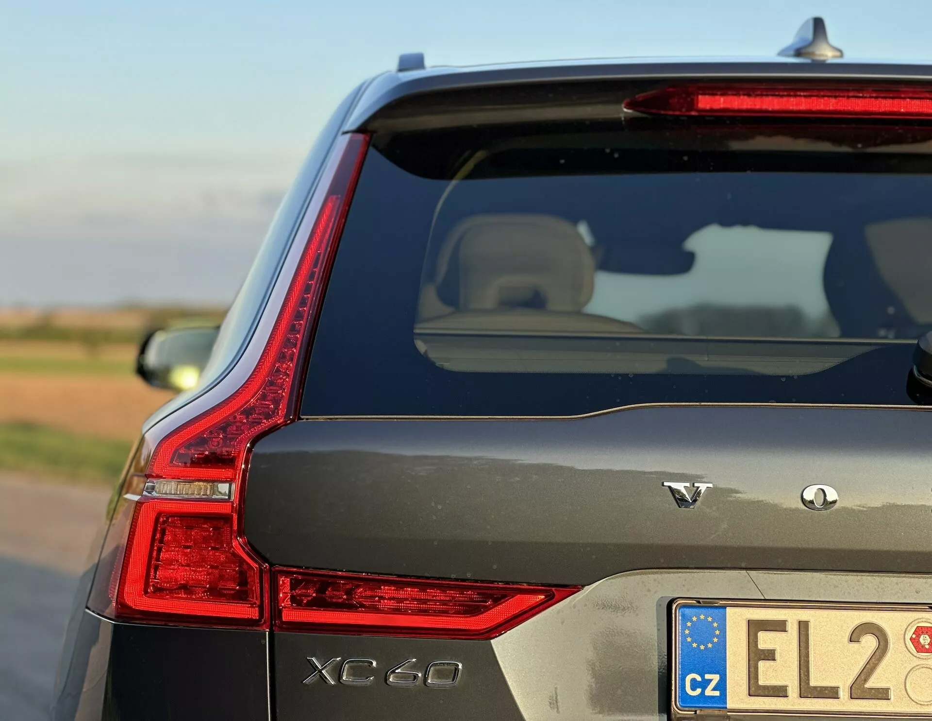 2021-es Volvo XC60 Recharge plug-in hibrid, amely természetes nappali fényben mutatja be elegánsan megtervezett LED hátsó lámpáját, AWD jelzéseit és különleges külső jellemzőit