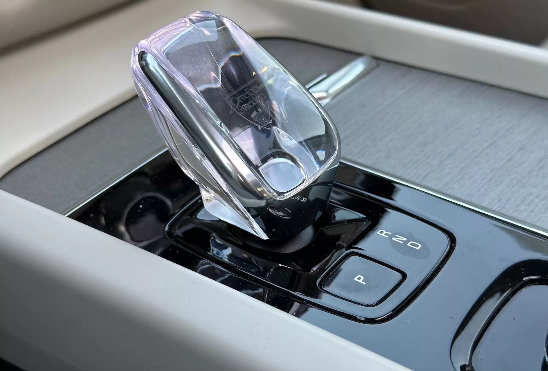 Közelkép a Volvo XC60 Recharge Plug-in Hybrid 2021 belső terének high-tech elektronikus váltókarjáról és érintésérzékeny vezérlőiről