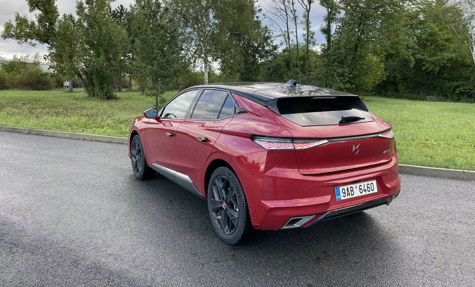 2017-es VW Golf GTD, élénk pirosban, hátulról háromnegyedes nézetben látható aerodinamikai kialakítással, LED hátsó lámpákkal, nagy ötvözetkerékkal és sötétített üvegekkel, kültéri parkolóban természetes háttérrel